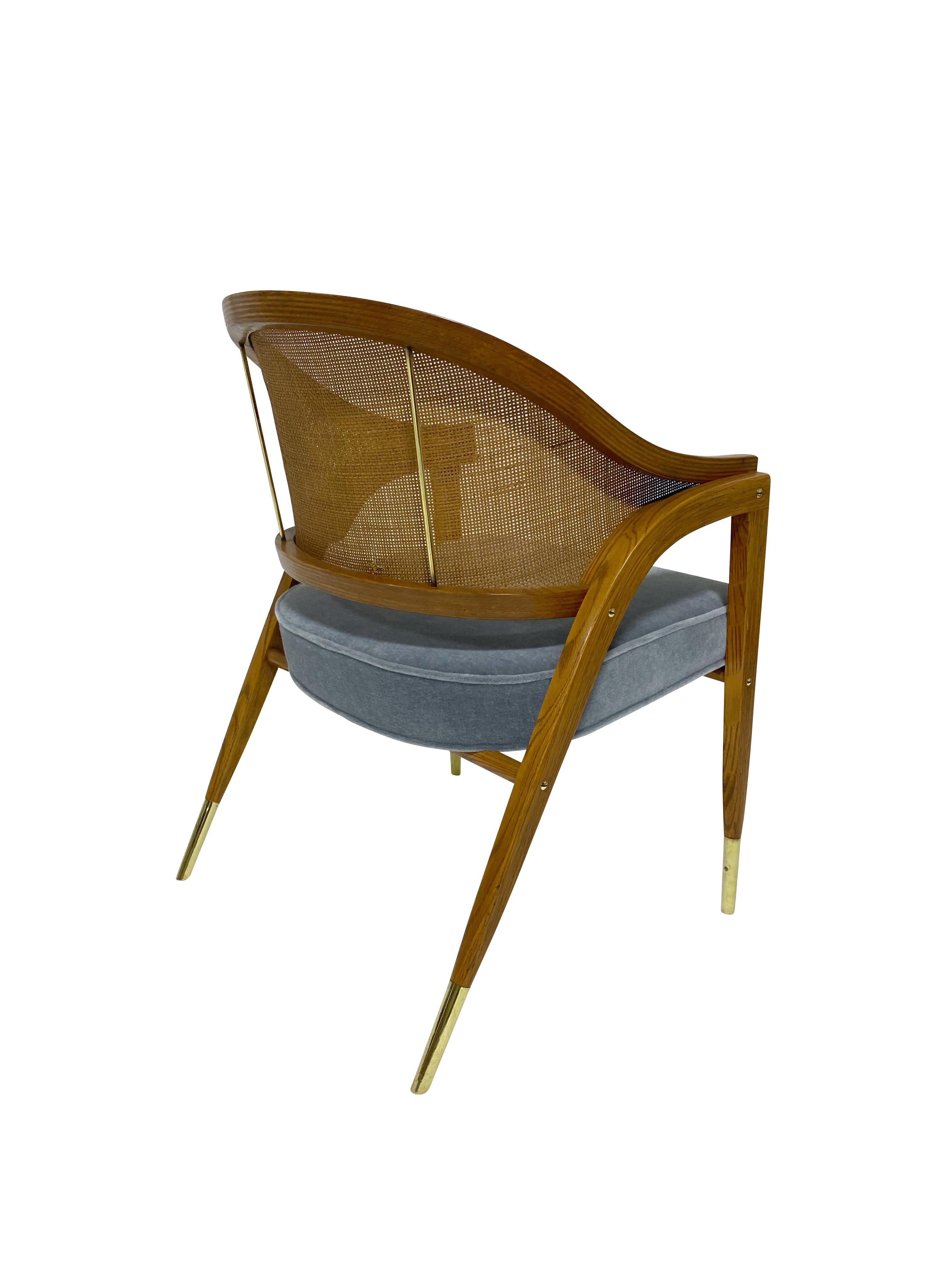 Armchair designed by Edward Wormley for Dunbar. Sculptural form frame made of laminated layers of ash with brass hardware, cane back, and newly upholstered mohair seat.