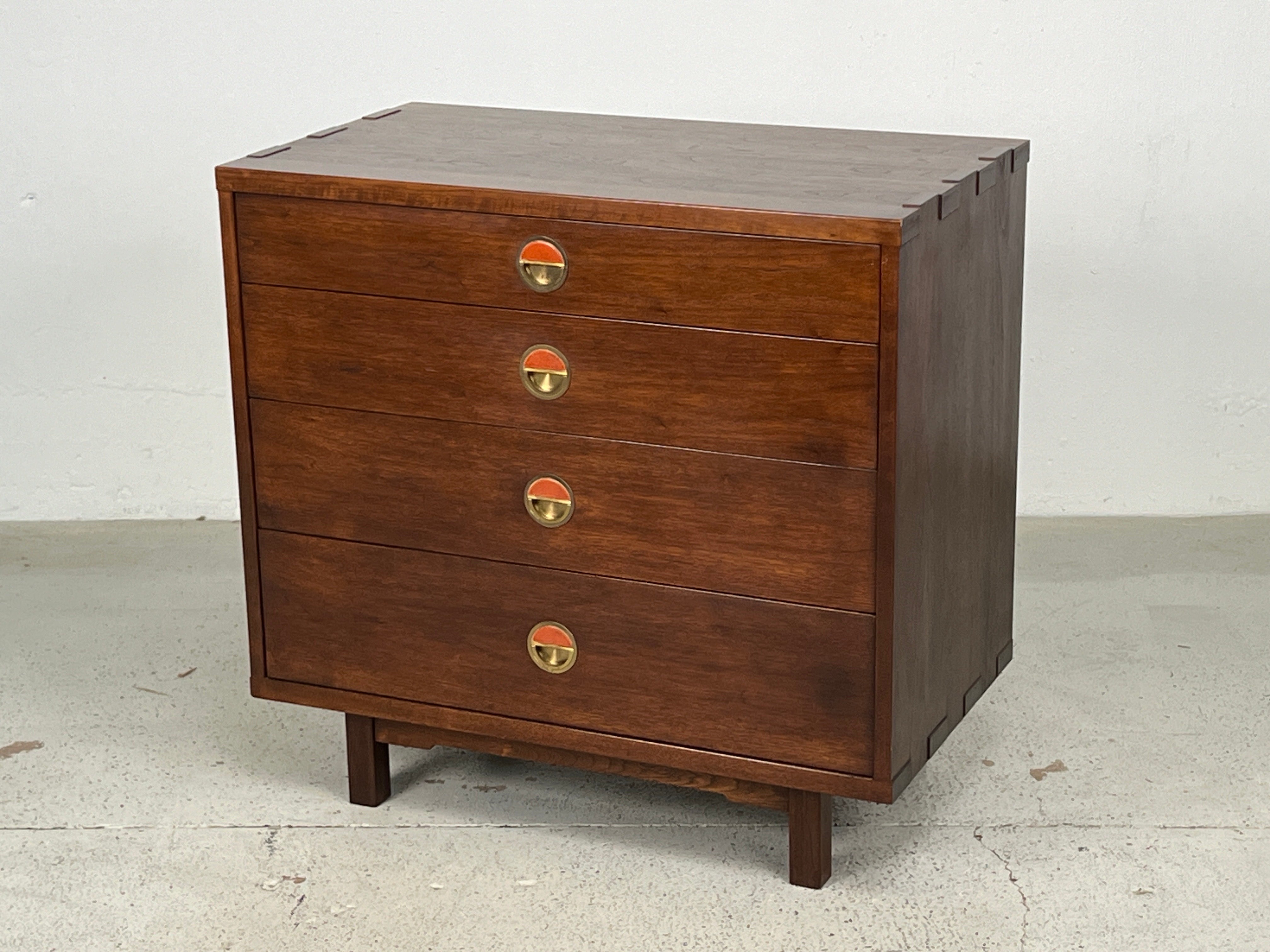 A rare chest designed by Edward Wormley for Dunbar. Solid walnut construction with exposed joinery and brass pulls with ceramic tiles by greta and Otto Natzler. 