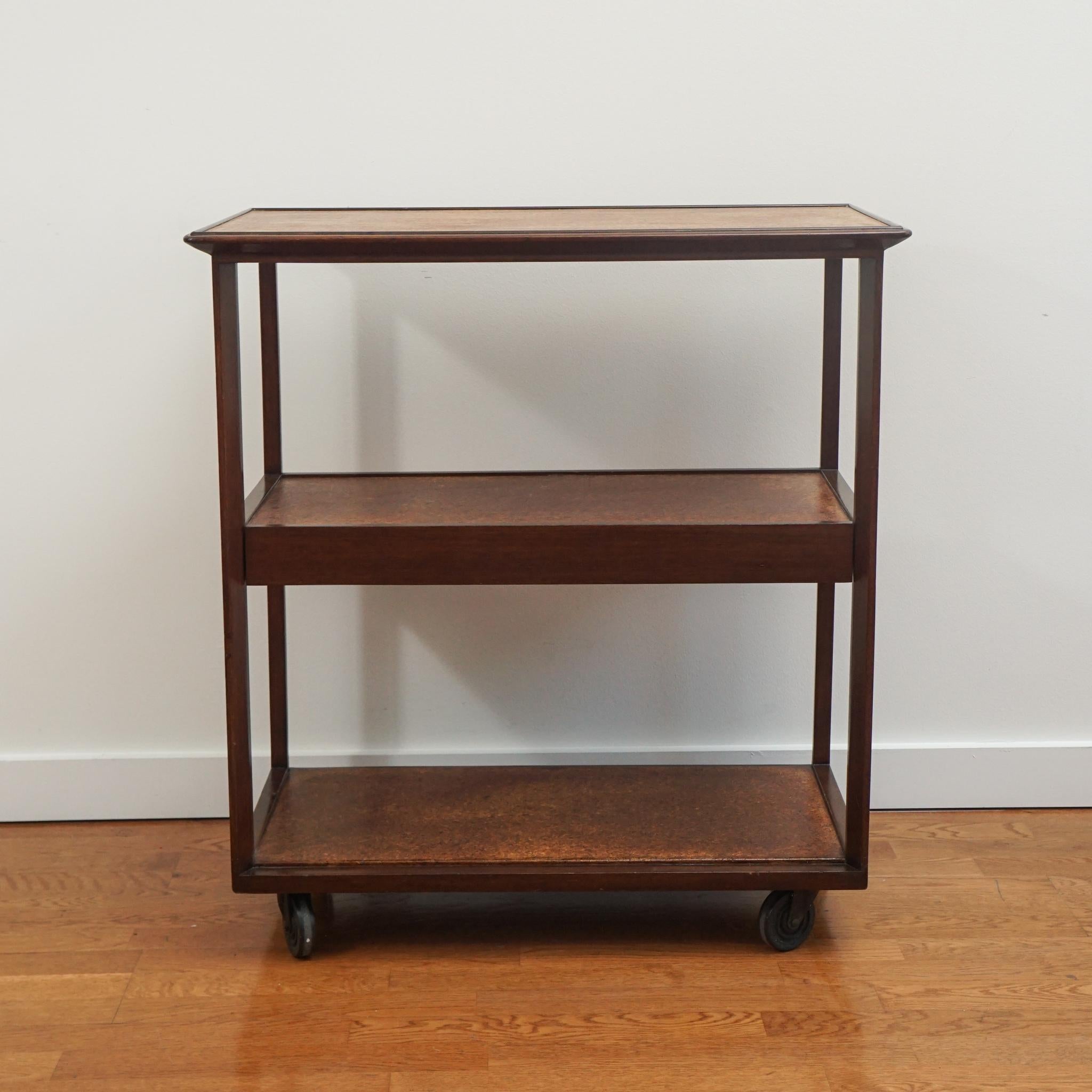 The Edward Wormley bar cart, shown here, is certain to make entertaining a little more special. Made for Dunbar, the rosewood frame cart features a cork inlay top and lower shelves. Casters add easy mobility. 
