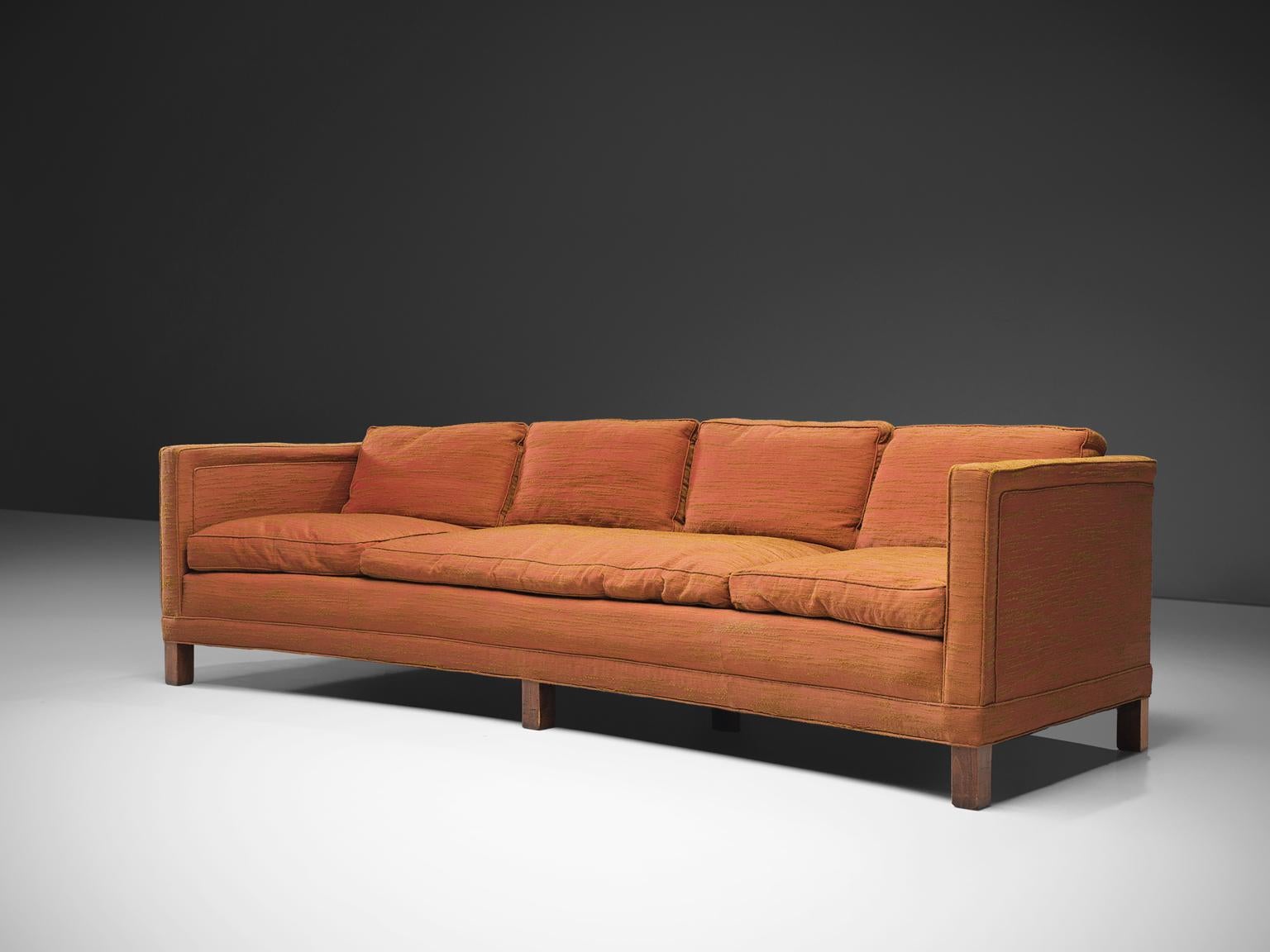 Dunbar sofa in orange fabric, United States, circa 1970s. 

This curved sofa has a particular upholstered fabric made with pink and ocre fibers, creating an interesting orange color. The sofa is made with four loose down filled back pillows and