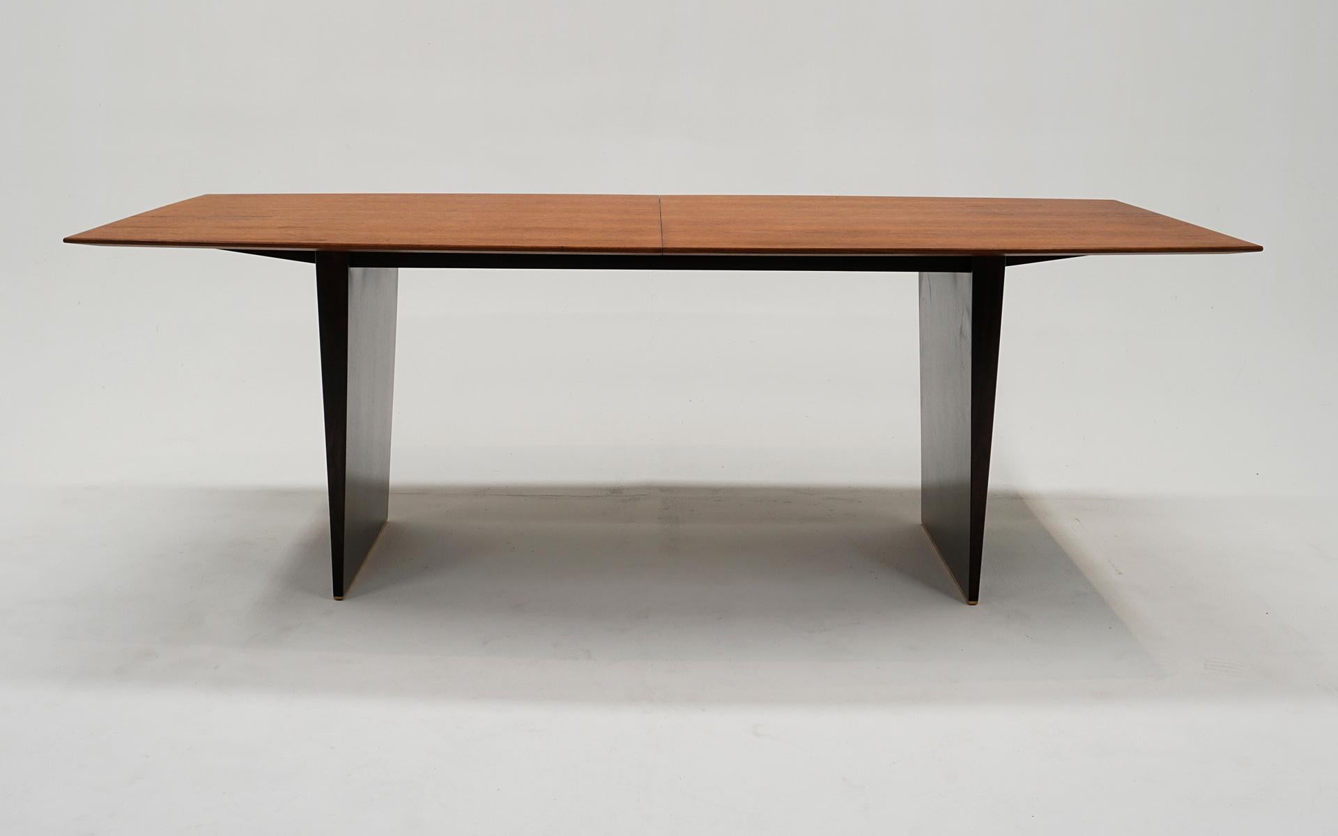 Magnifique table de salle à manger à rallonge modèle 5460A conçue par Edward Wormley pour Dunbar. Plateau effilé en acajou moyen et socle en acajou foncé avec des pieds en laiton sur toute la largeur de la base. Trois feuilles de douze pouces font