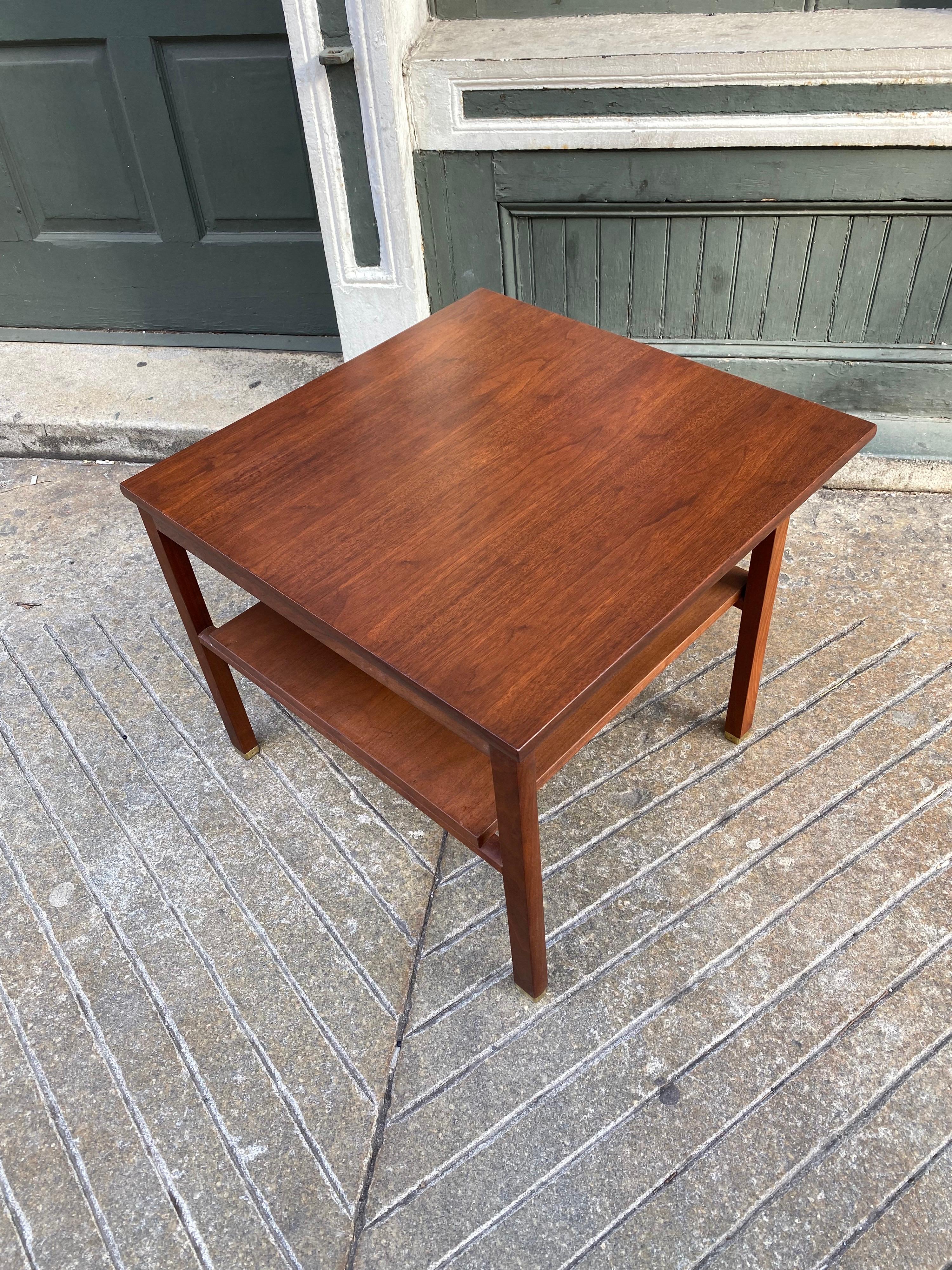 Dunbar Mahogany endtable with brass capped feet. Top overhangs on 2 sides in an asymmetrical design. Retains Dunbar badge to underside.