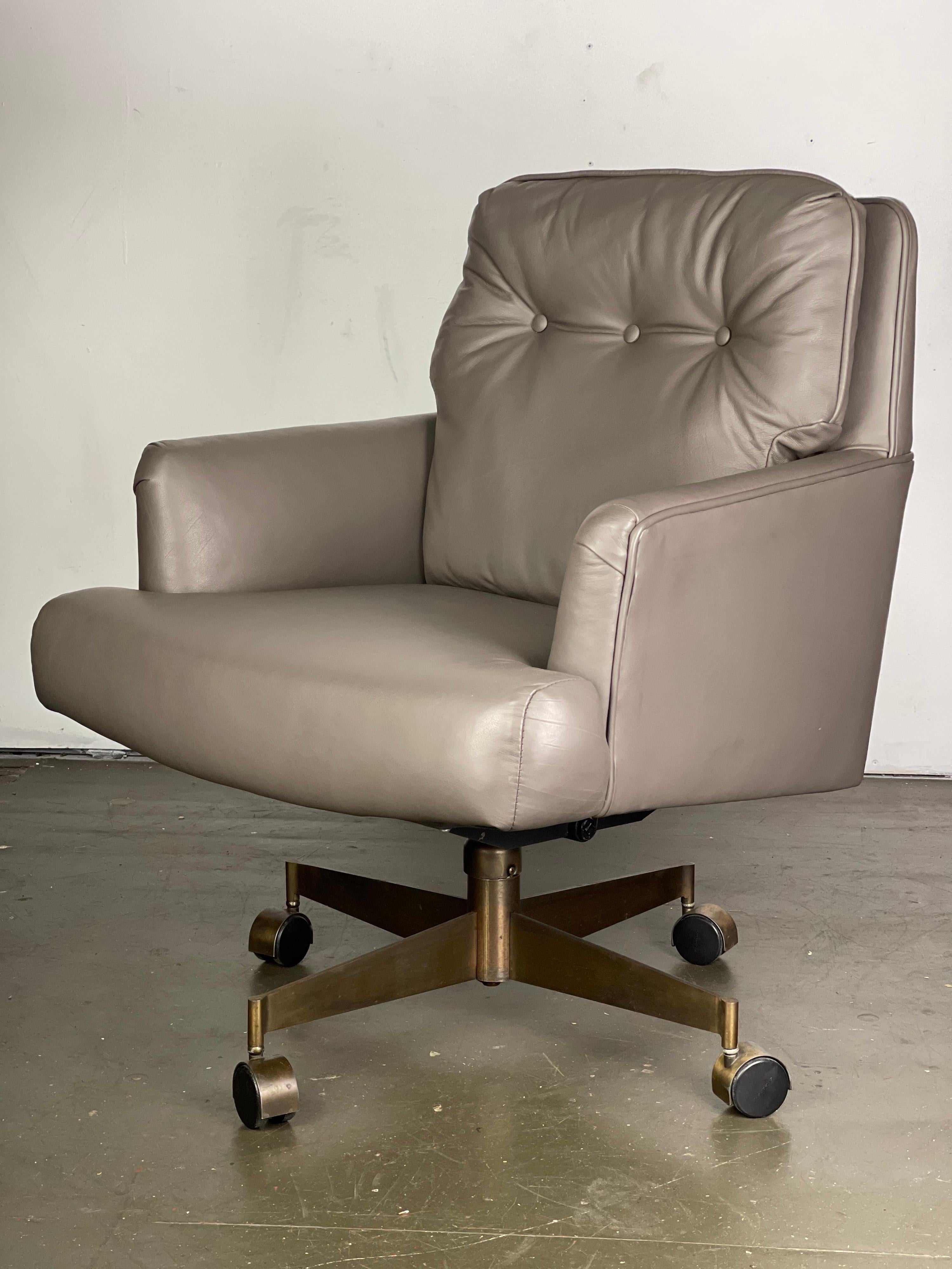 Reupholstered Dunbar executive office chair. Redone in a soft grey leather. Antiqued brass base. Rolls and tilts and swivels wonderfully. Spins up and down - photographed at 19
