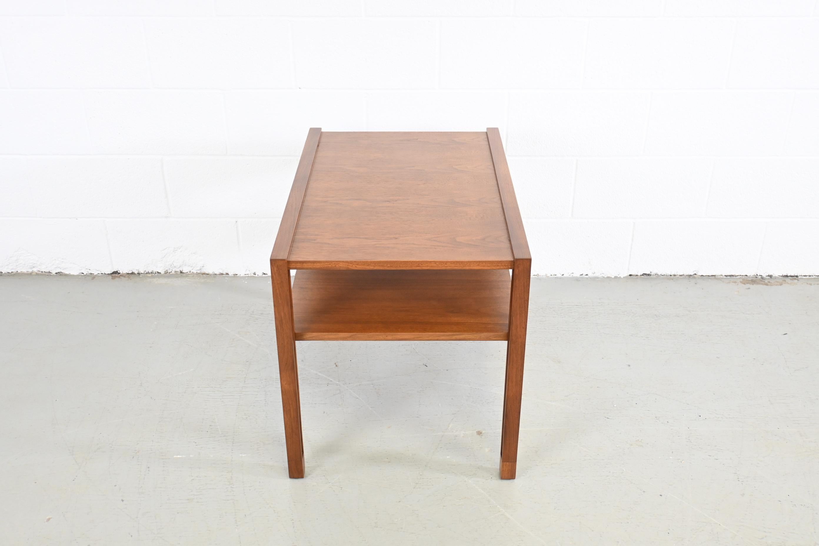 Dunbar Mid-Century Modern two tiered walnut end table.

Dunbar Furniture, USA, 1950s, Unmarked.

Measures: 20 wide x 29.5 deep x 22.25 high.

Mid century modern walnut coffee table with shelf.

Professionally refinished. Excellent condition.