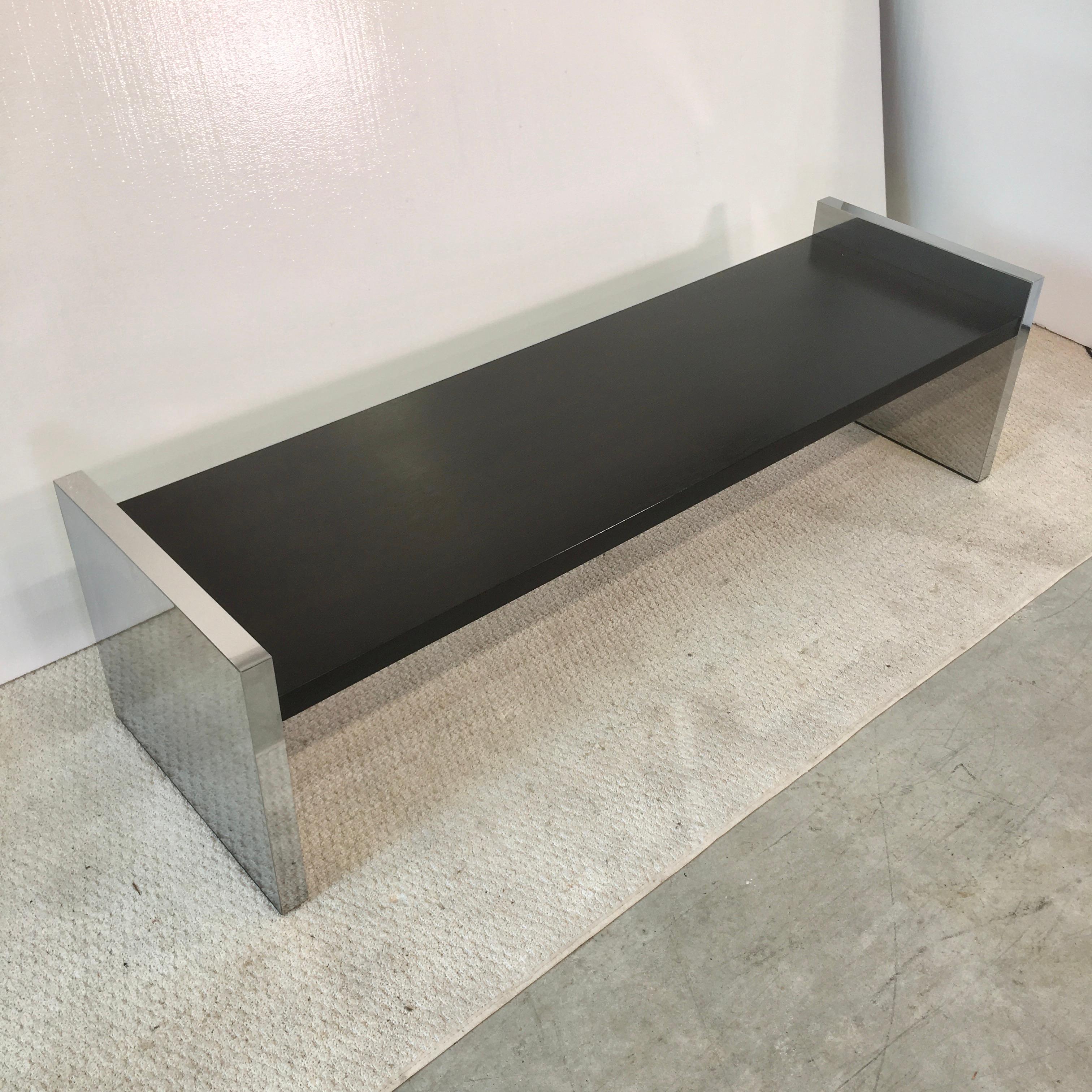 This is the 60 inch long version of this bench (or table) designed by Roger Sprunger for Dunbar circa 1970. Ebonized solid oak between two mirror polished stainless steel clad slab sides. Dunbar metal tag on underside Hand polished and ready to