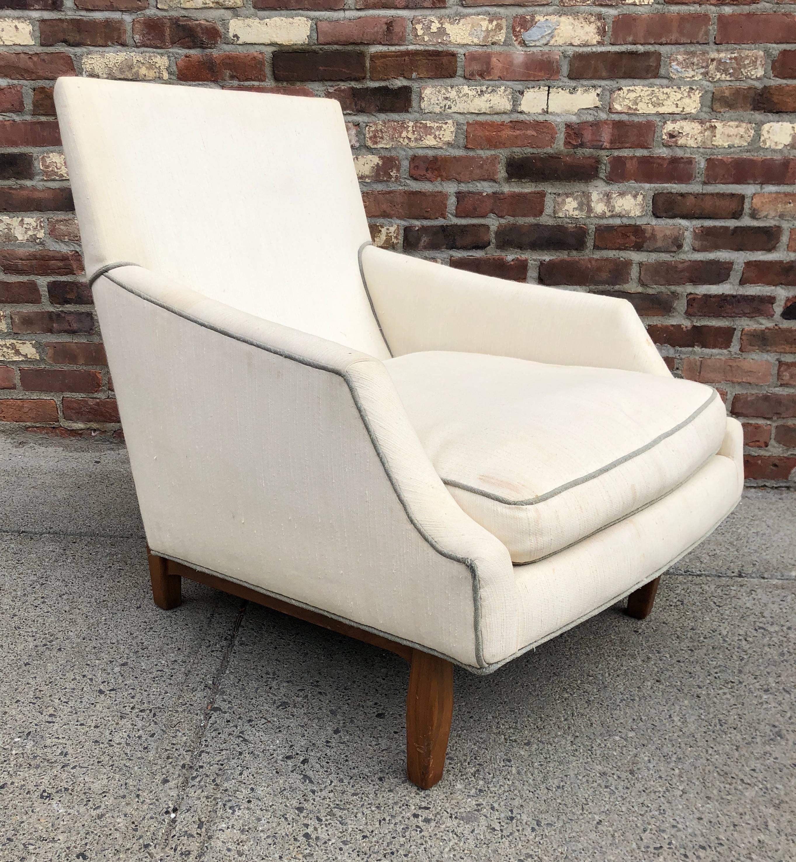Loungesessel mit hoher Rückenlehne und scharf geschnittenem, abgewinkeltem Sitz auf geschnitzten Nussbaumbeinen, ca. 1950er Jahre. Unsigniert, wird aber Dunbar Furniture zugeschrieben.