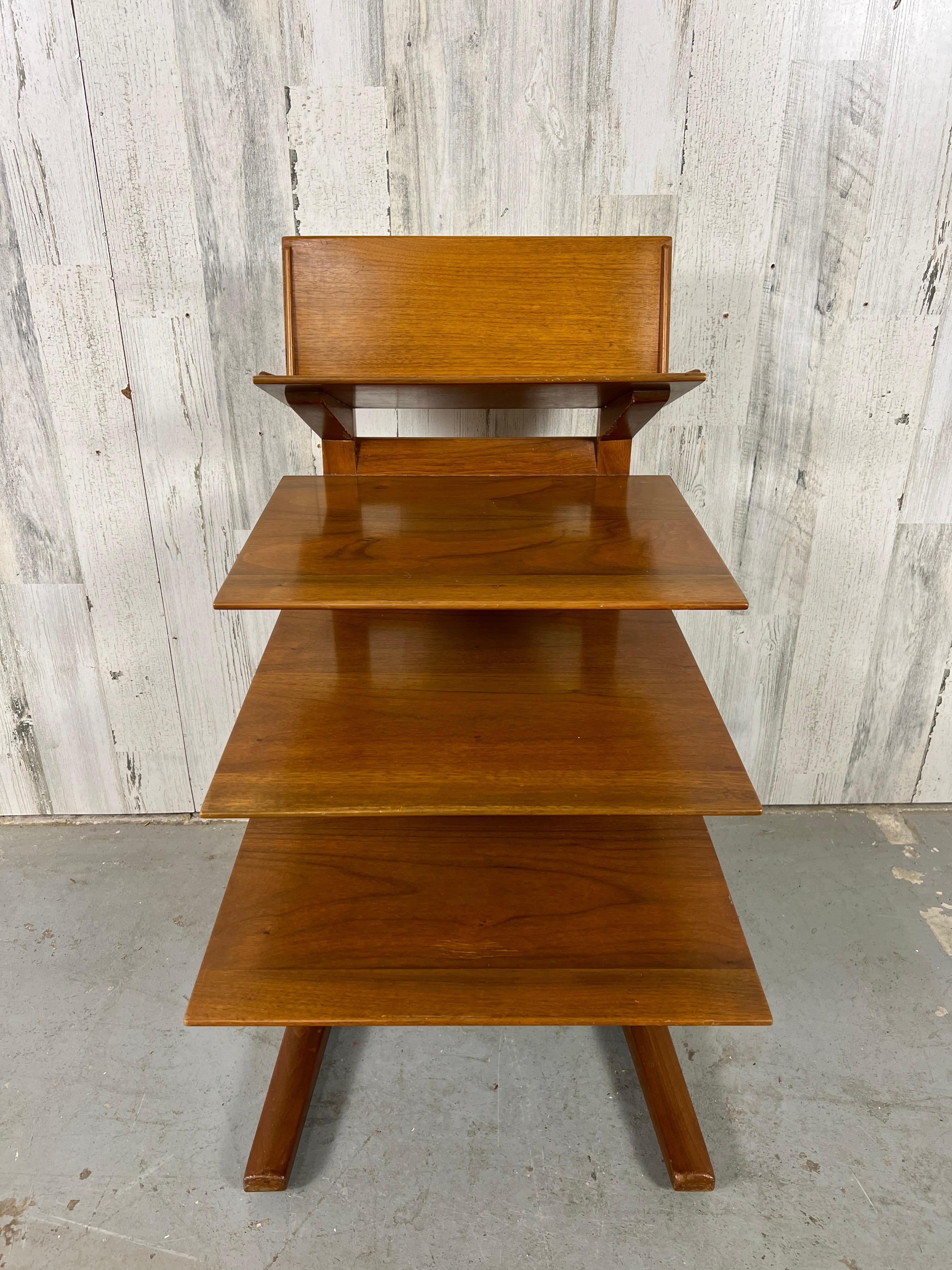 Edward Wormley for Dunbar magazine tree in walnut with four cantilevered shelves that get deeper as the order descends from top to bottom. A rare model introduced in 1953 and was only produced for two years. This table is original with a beautiful