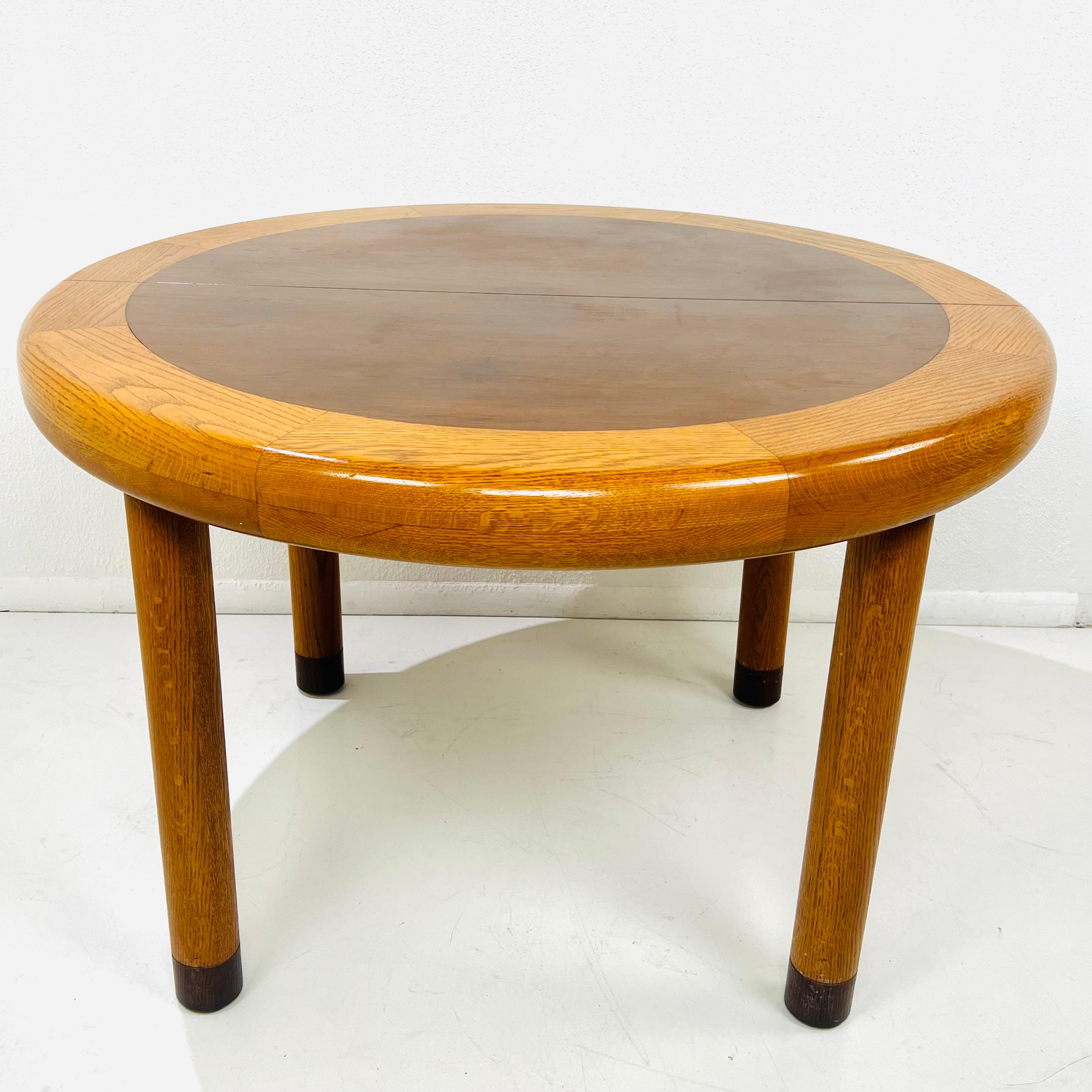 An exceptional Mid-Century Modern dining table or game table by Dunbar. Features a gorgeous rosewood top, with oak banding and cylindrical legs. Made in USA, 1970s. Good vintage condition with some surface imperfections (scratches, scuffs, dings,