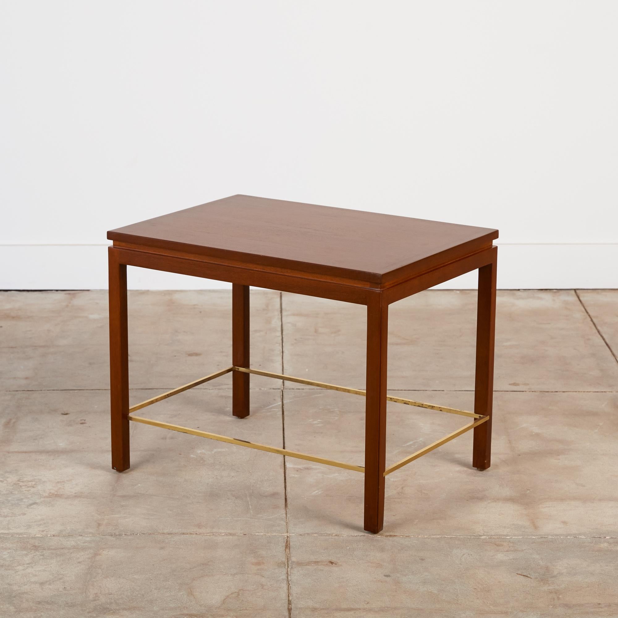 A nearly square side table designed by Edward Wormley for Dunbar. The model 310 has four square post legs that sit flush with the corners of the piece. Each leg is notched to fit a brass stretcher that defines the interior edges of the table. The