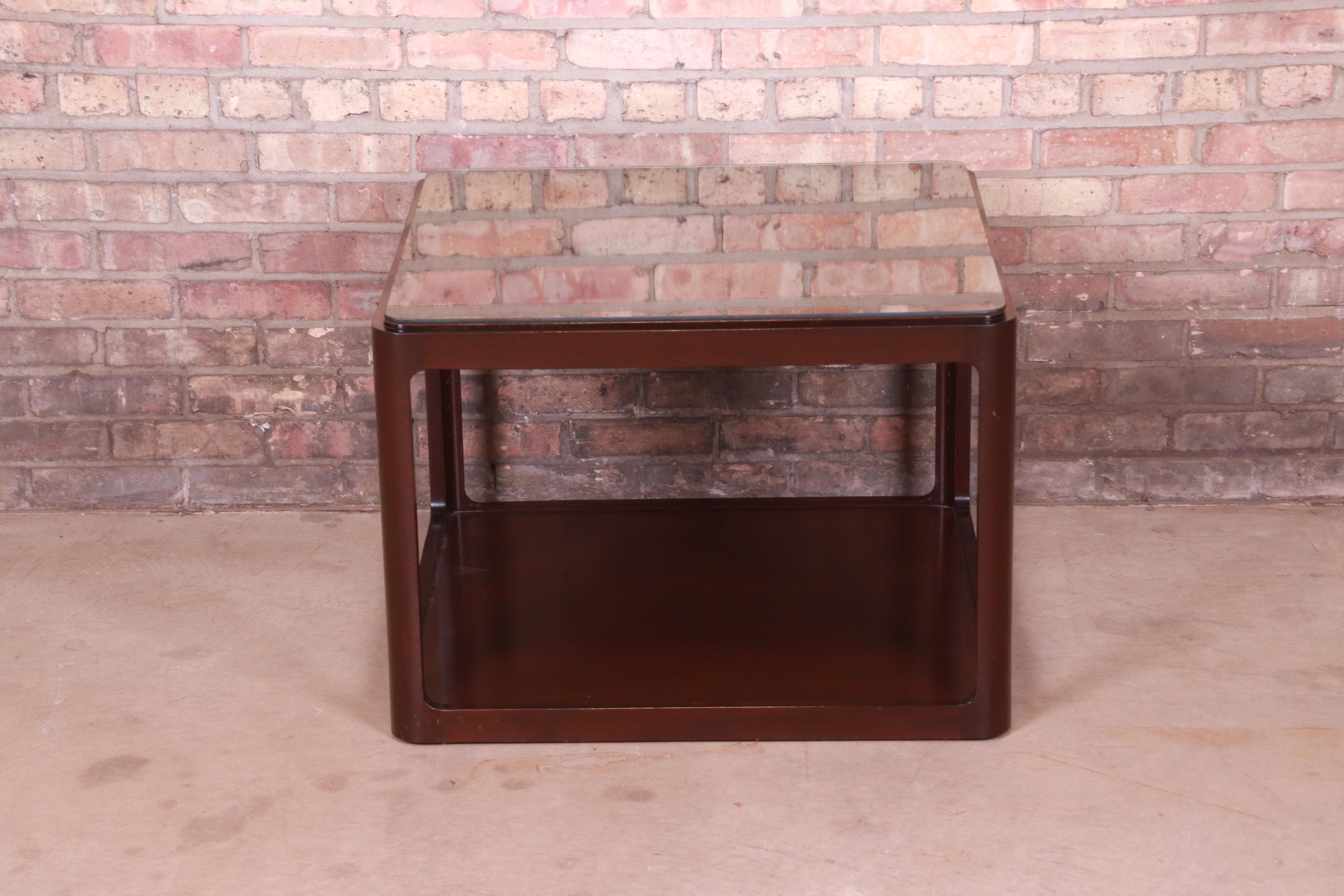 A gorgeous modern two-tier cocktail table or occasional side table

By Roger Sprunger for Dunbar Furniture

USA, Late 20th Century

Sculpted walnut, with custom glass top.

Measures: 29
