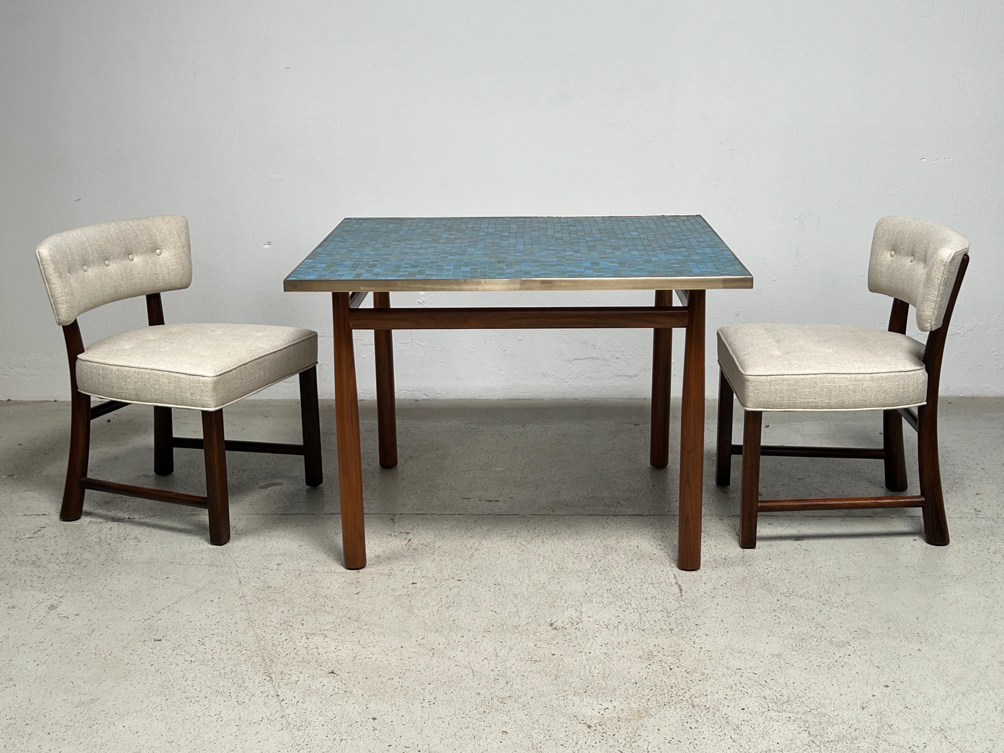 A rare Murano glass tile top game / dining table with brass edging and tapered mahogany legs. Designed by Edward Wormley for Dunbar with early green Dunbar label. This is the largest Murano tile table Dunbar offered and there has not been another on
