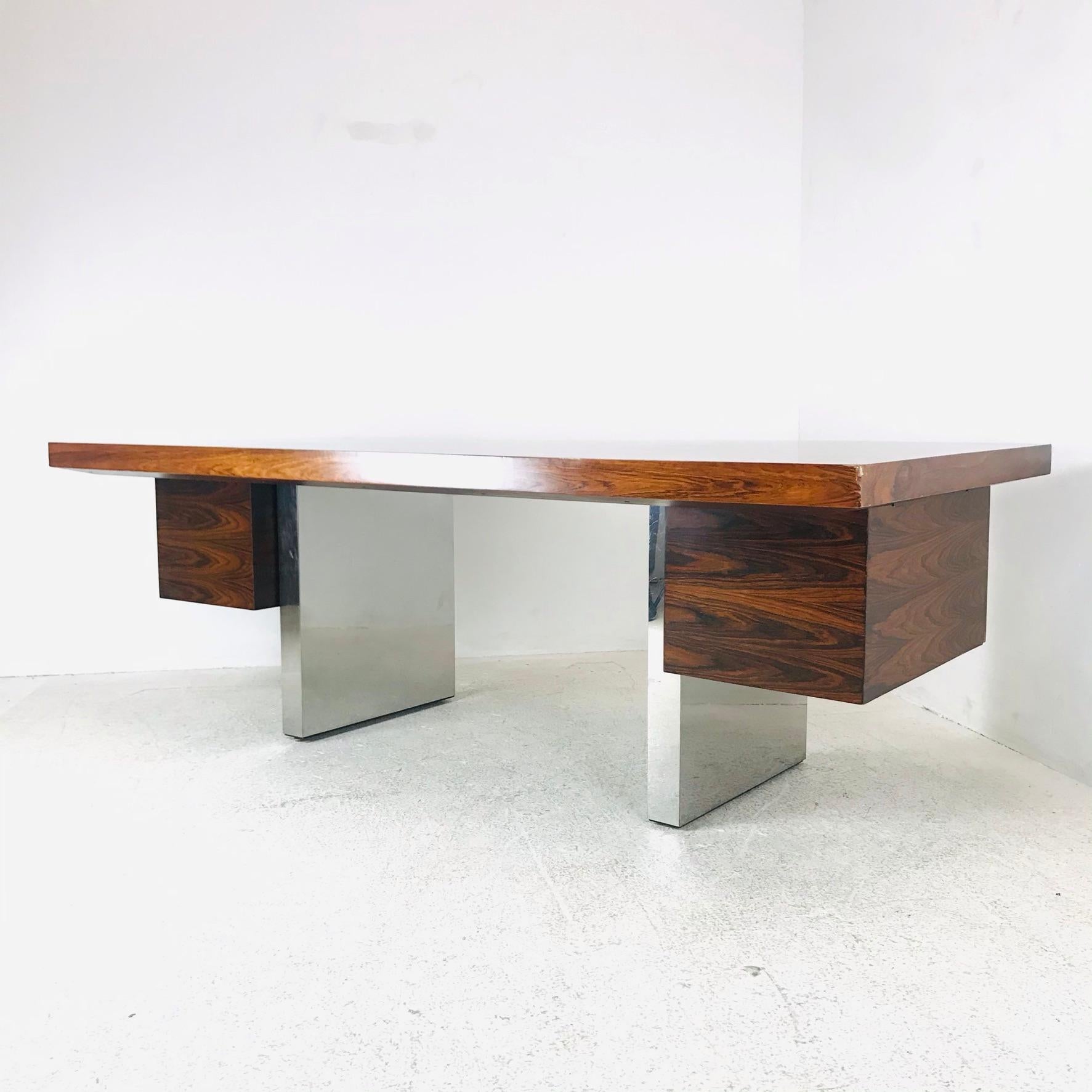 A Mid-Century Modern Dunbar executive desk in the style of Roger Sprunger. Rosewood with chrome double pedestal base. Includes one file drawer, two regular drawers, and middle drawer. Some scratches and wear, see pictures for details.