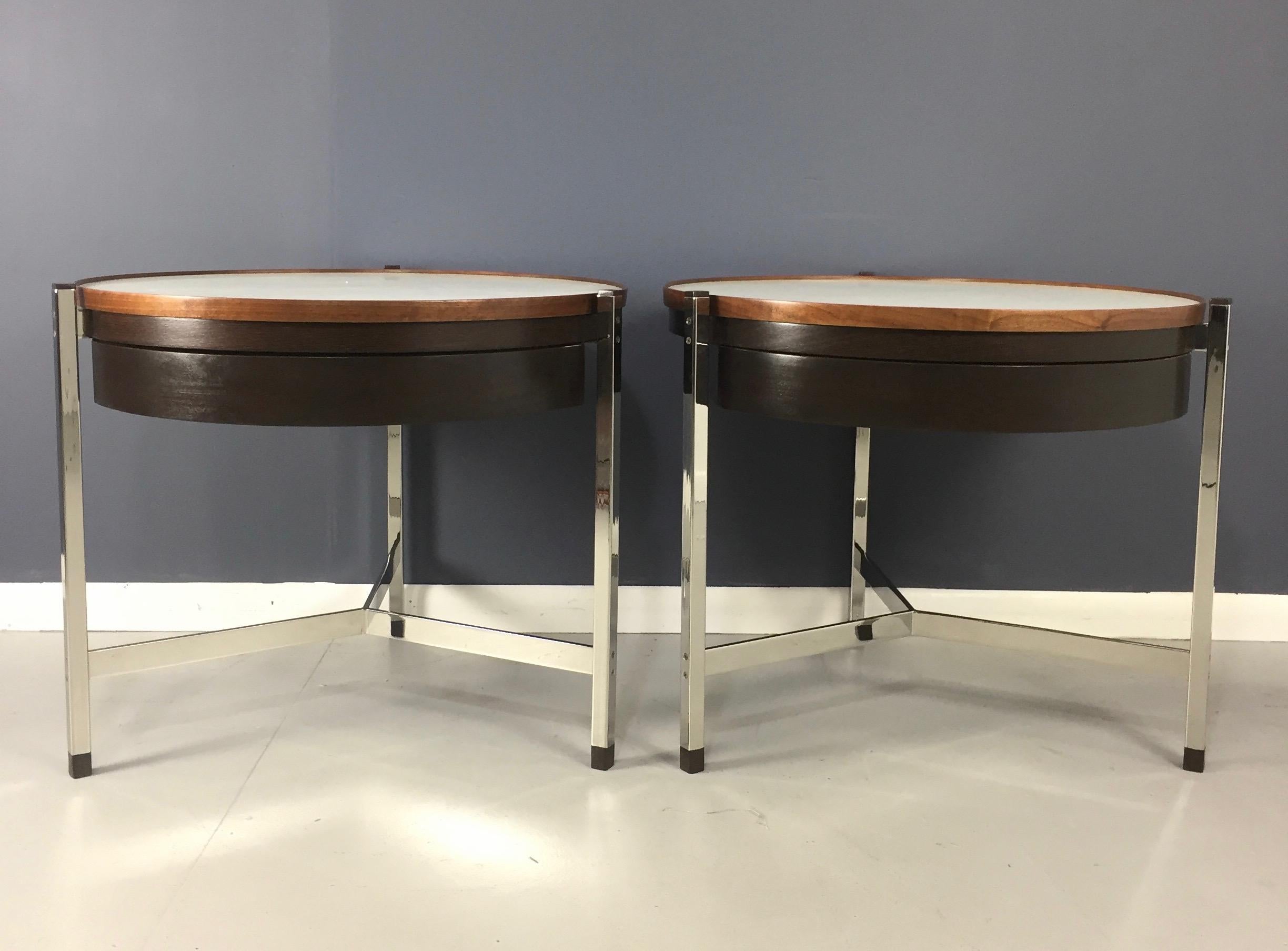 A pair of exceptionally rare and unusual round occasional tables in walnut and rosewood with Micarta tops and stainless steel structure. Tables with a single drawer and rosewood feet and caps.

These tables have gone through an extensive