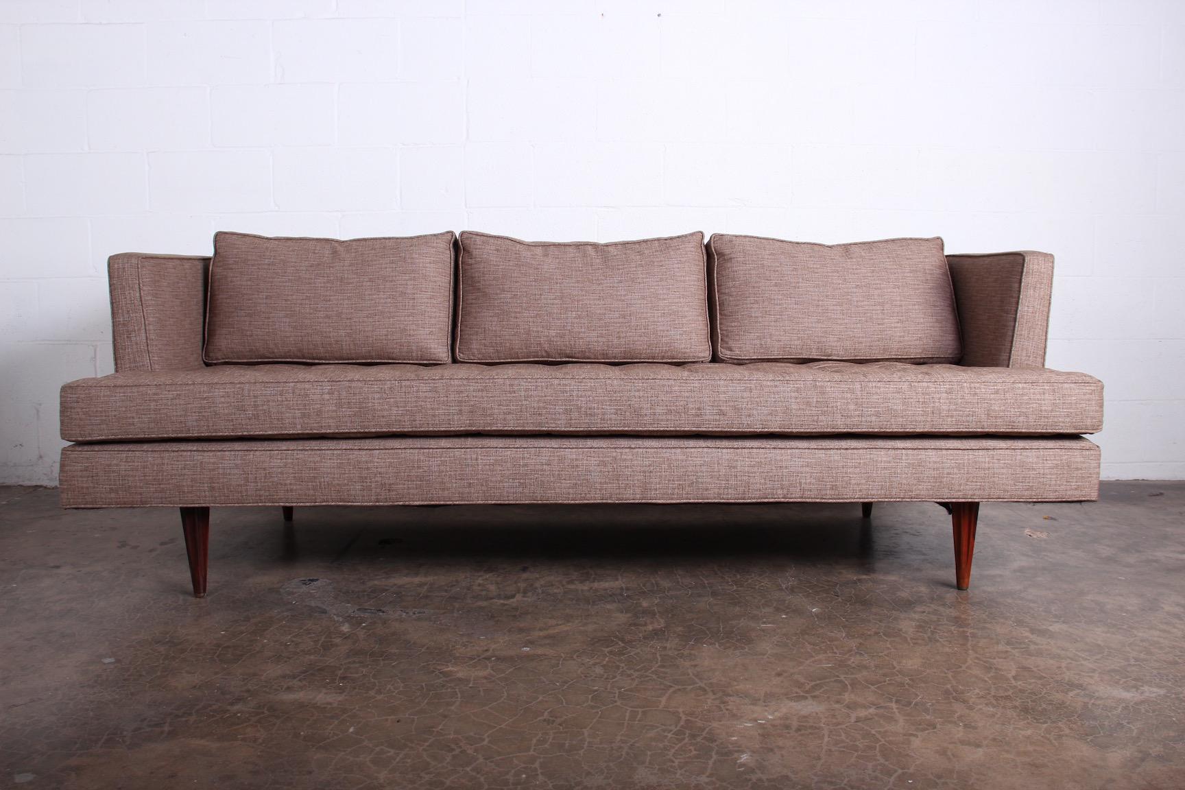 A sofa designed by Edward Wormley for Dunbar. Fluted rosewood legs with brass caps.