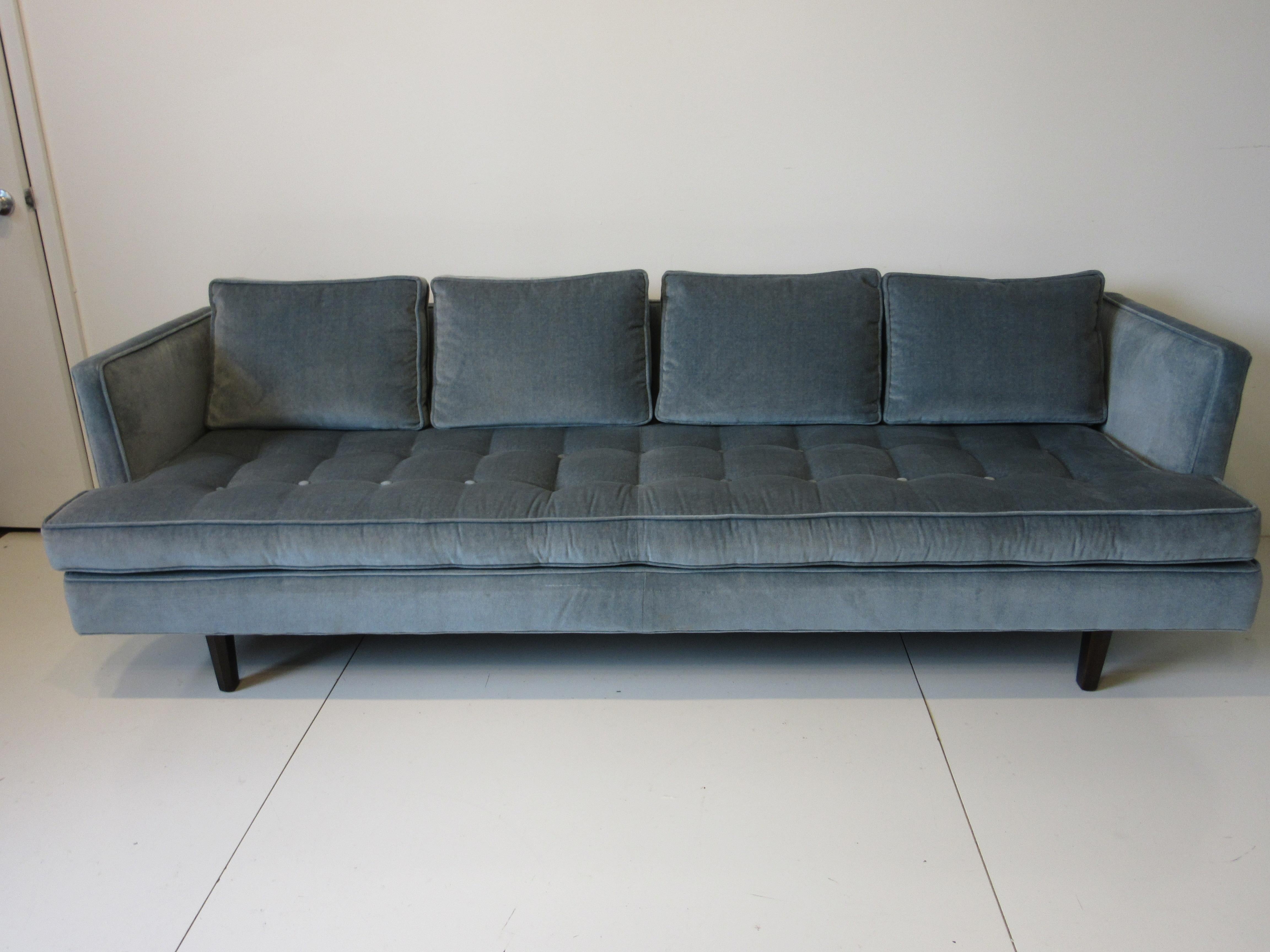 A well crafted sofa in a blue steel toned velour / velvet with button bottom and back having four down filled back cushions . The legs are in a ebony finished mahogany as with all sofas manufactured by Dunbar the springs are all hand tied and lower
