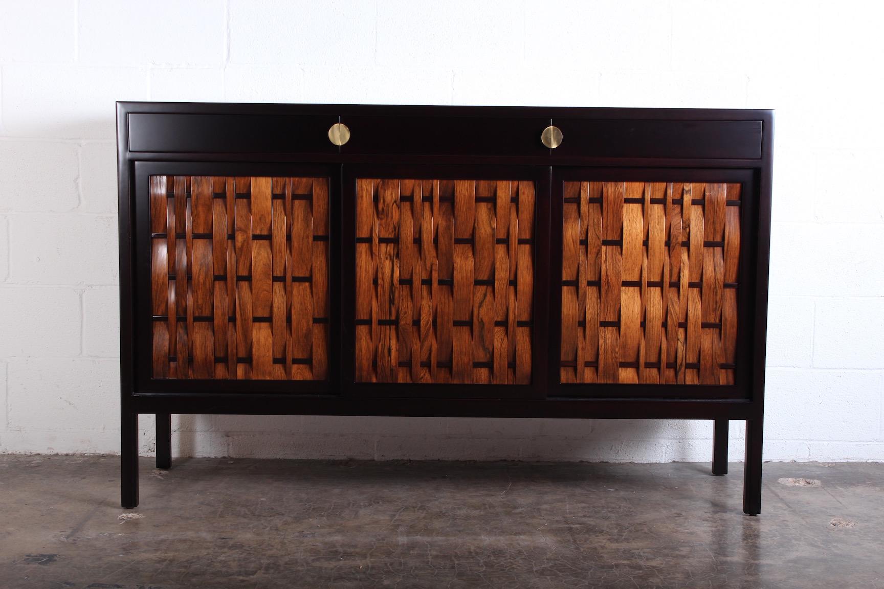 A mahogany cabinet with rosewood woven doors and brass hardware designed by Edward Wormley for Dunbar.