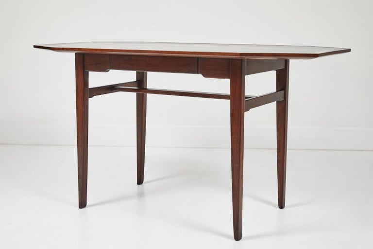 This is a Dunbar writing desk designed by Edward Wormley. This desk has the original order ticket taped under the drawer and features the original finish. The drawer includes a built in tray for your writing materials and you styluses. This is a