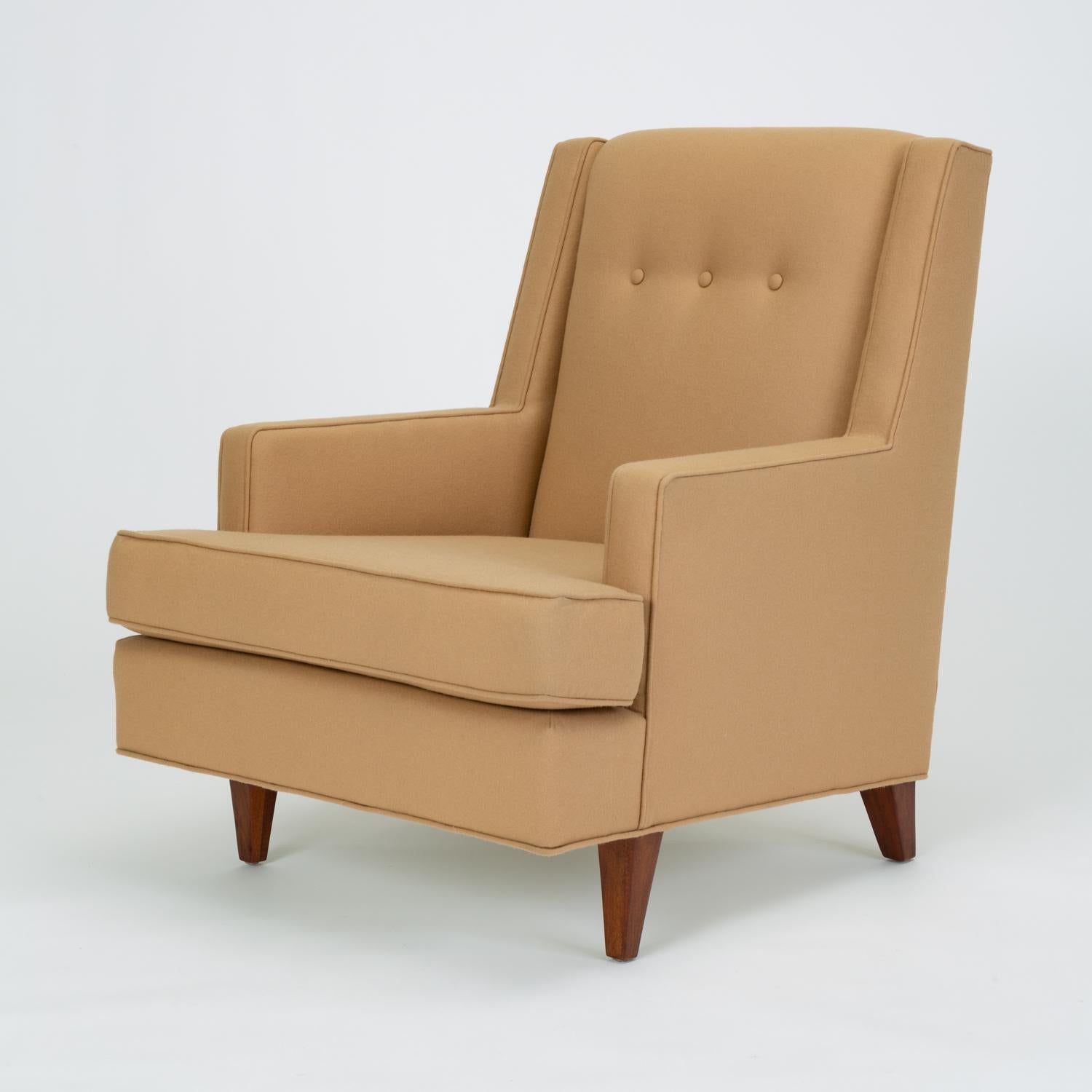 A “Mr.” chair from one of Edward Wormley his-and-hers chair pairings for Dunbar, this example has in soft brown wool felt has a high back, sloped sides and arms, and sits on four thick legs that taper slightly to the floor. A single row of tufting