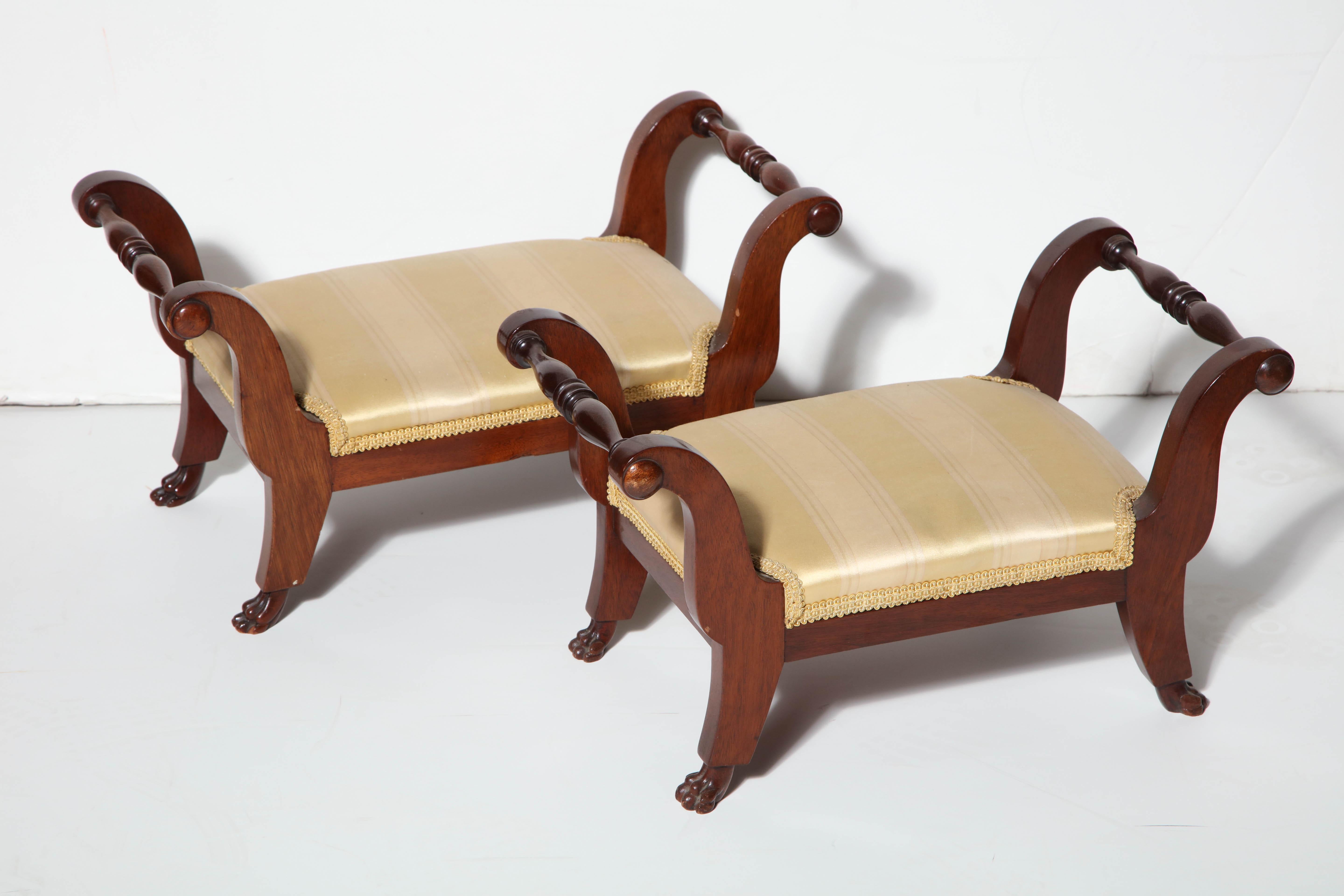 Pair of New York Duncan Phyfe mahogany small foot stools in the form of window benches with carved dog feet.