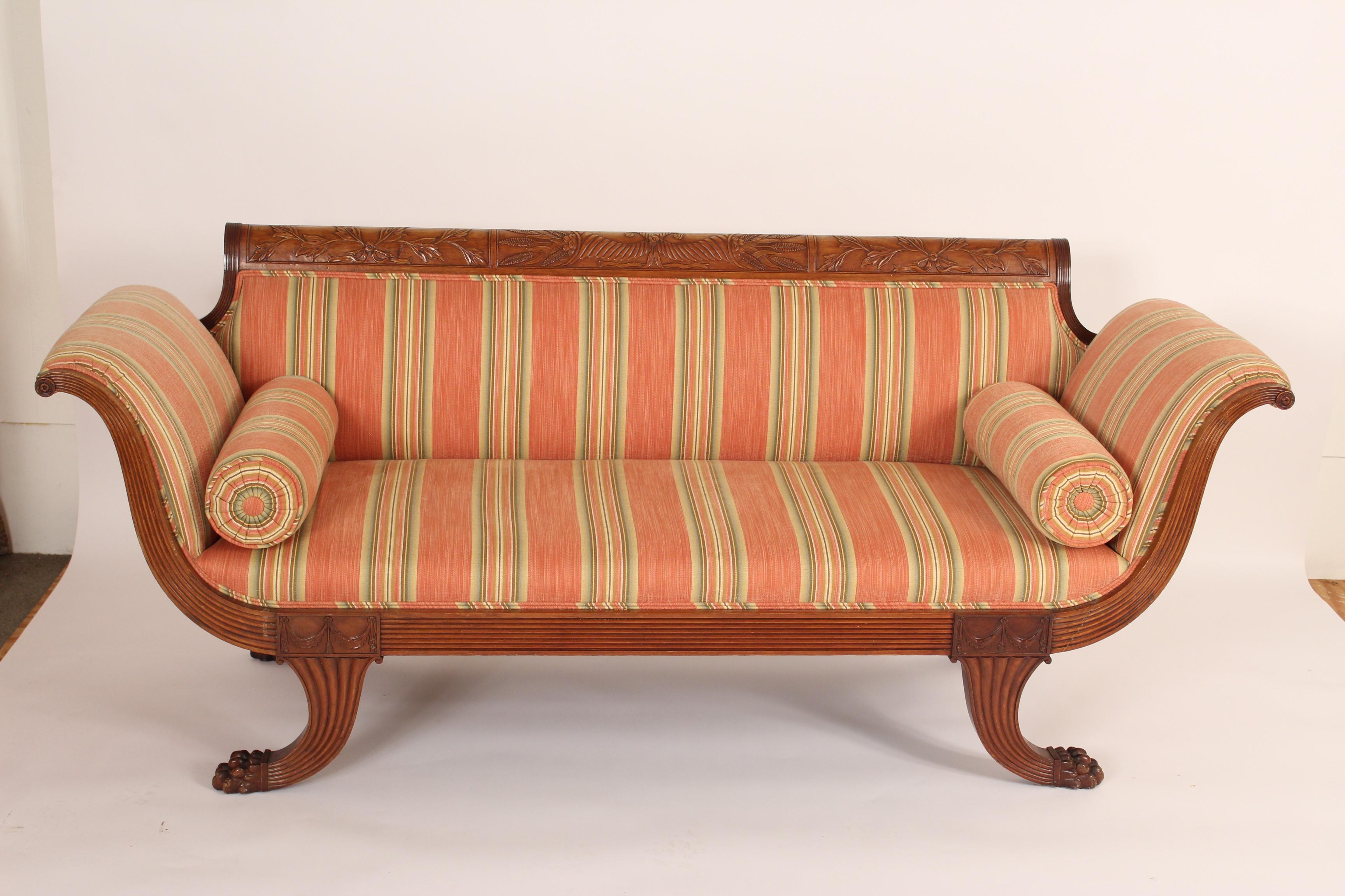 Duncan Phyfe style carved mahogany sofa, circa 1920s. The crest rail having interesting cornucopia and vine carving, apron has swag carvings, and the sofa is resting on unusual carved paw feet. Nice older patina. The upholstery is in excellent