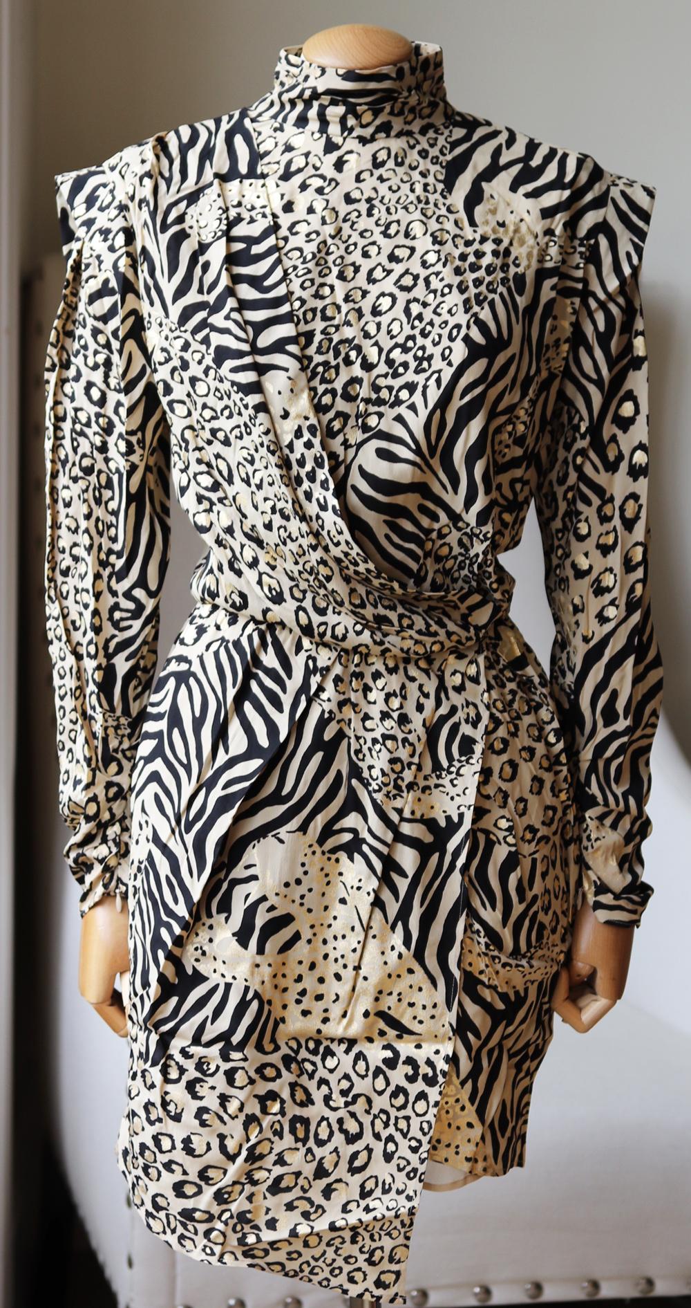Dundas mini dress is intricately printed with a mix of various animal-prints, most noticeably leopard-spots and zebra-stripes.
This dress combines different structural elements with strong shoulders, a turtleneck collar and a pleated asymmetric