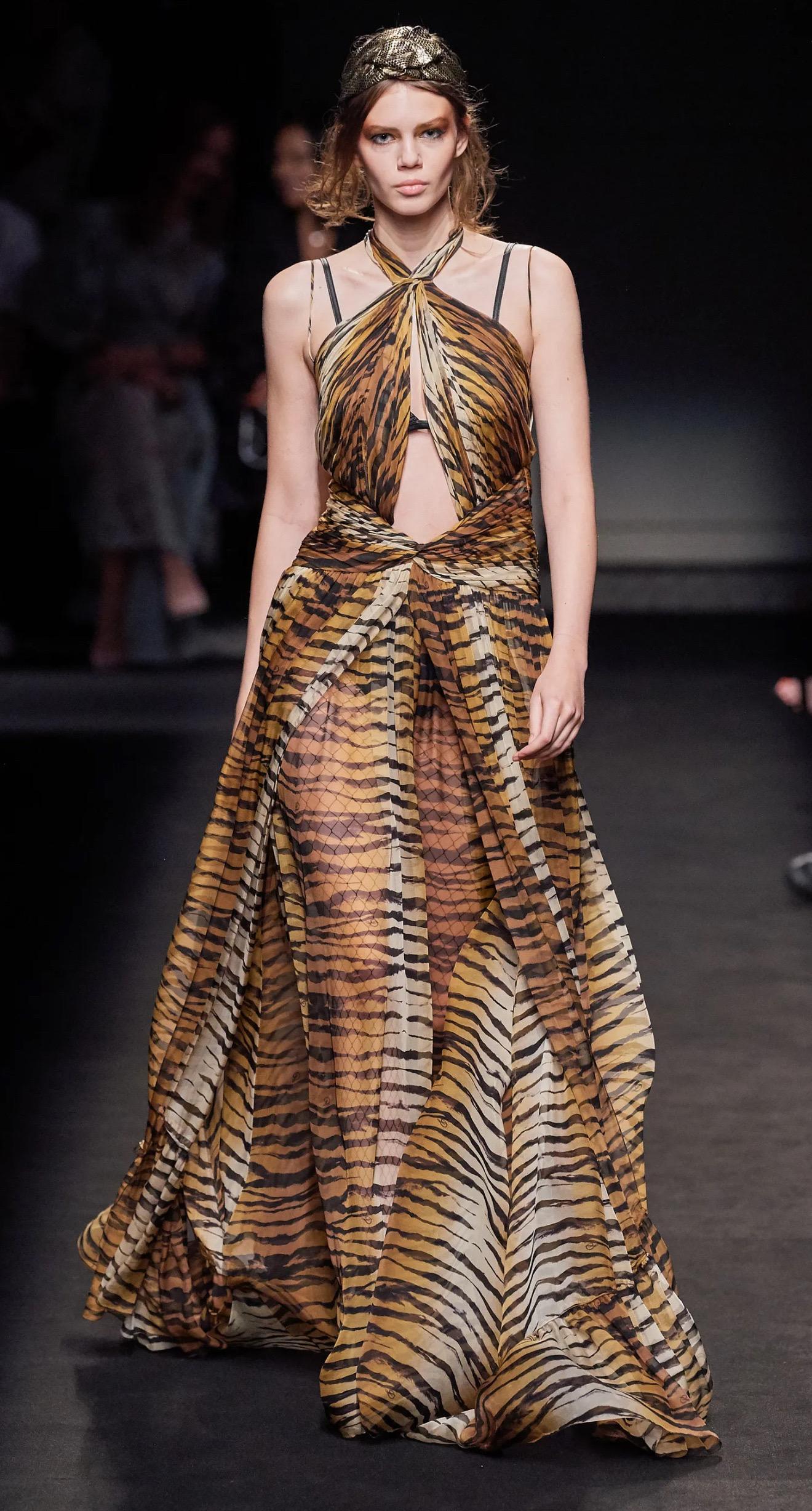 From Dundas’s Fall 2019 Couture collection, this dramatic tiger-print gown is a showstopper—featured on the runway as Look 36.
Crafted in luscious layers of semi-sheer silk chiffon, it features a twisted halter neckline, a cutout bodice, thigh-high