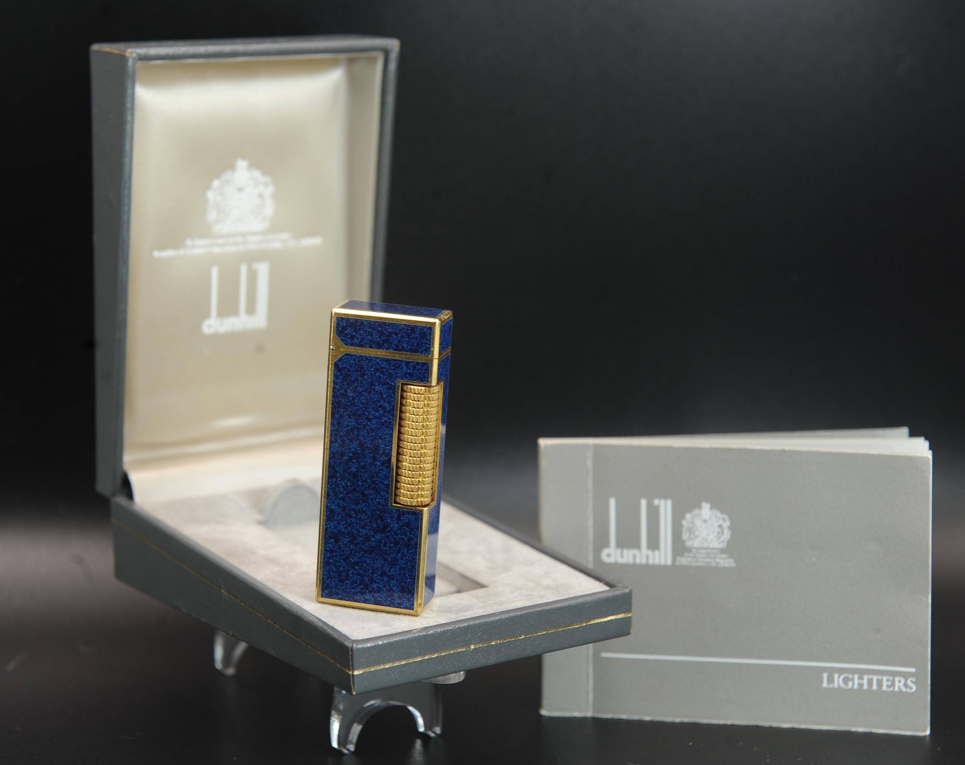 Accendino Rollagas laccato in marmo blu placcato oro 18ct di Dunhill.
Un classico accendisigari Made in Switzerland con scatola di Dunhill  

Inscritta con 