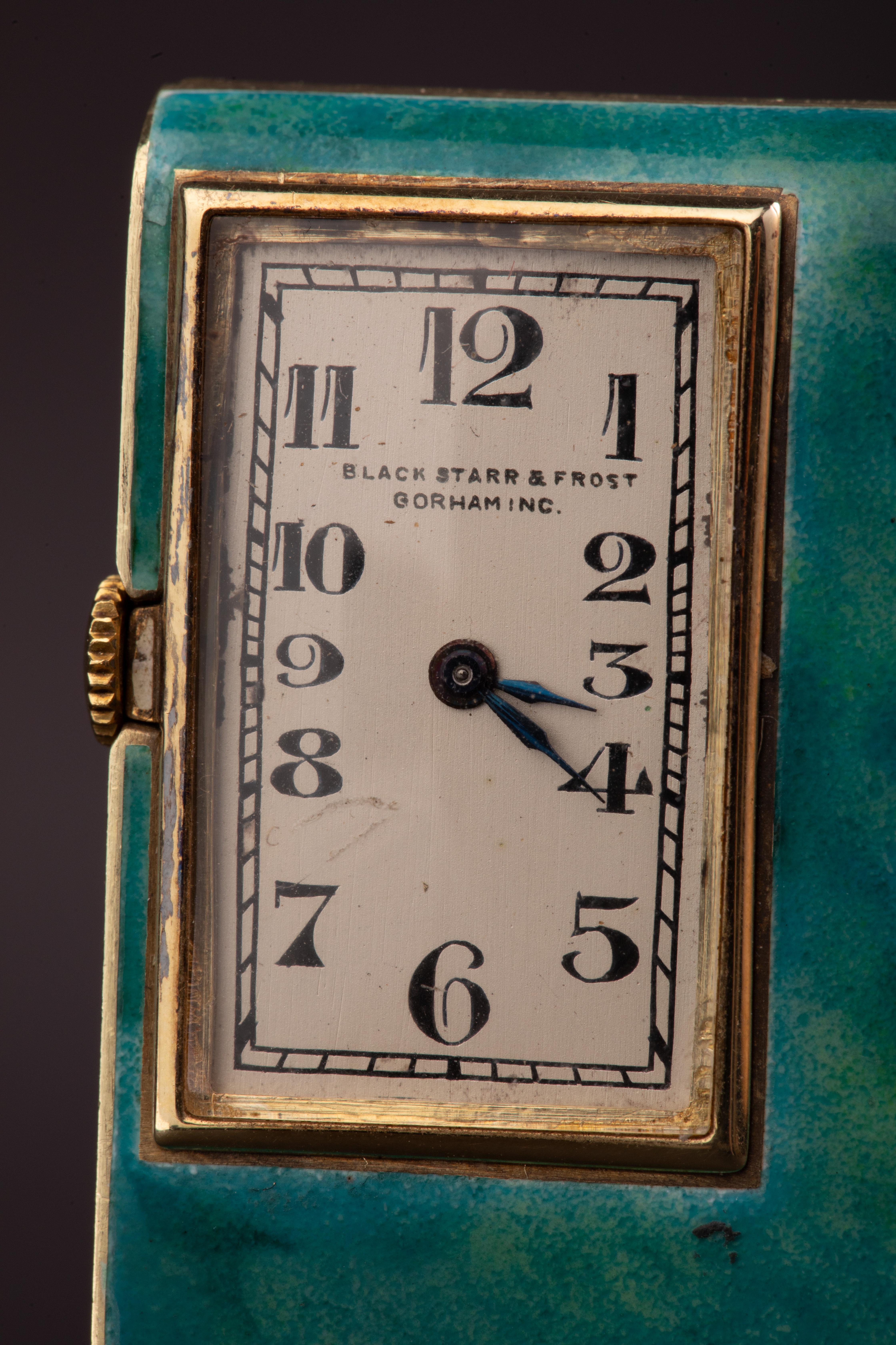 Whiting comprend un rouge à lèvres et un poudrier avec miroir intégré, une montre et un briquet de table assorti, tous finement travaillés en or 14 carats et ornés de panneaux d'émail bleu-vert vibrant dans une finition marbrée, bordés d'accents