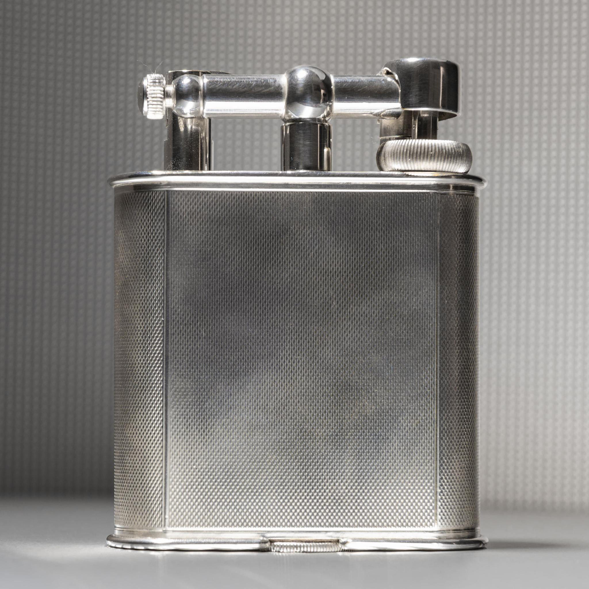 A fine engine turned silver plated Dunhill lighter for table or desk; circa 1948. The 'Giant' lighter was first seen in the Dunhill catalogue in 1929 and was an immediate success.

Dimensions: 10.5 cm/4? inches (height) x 8 cm/3? inches (width) x