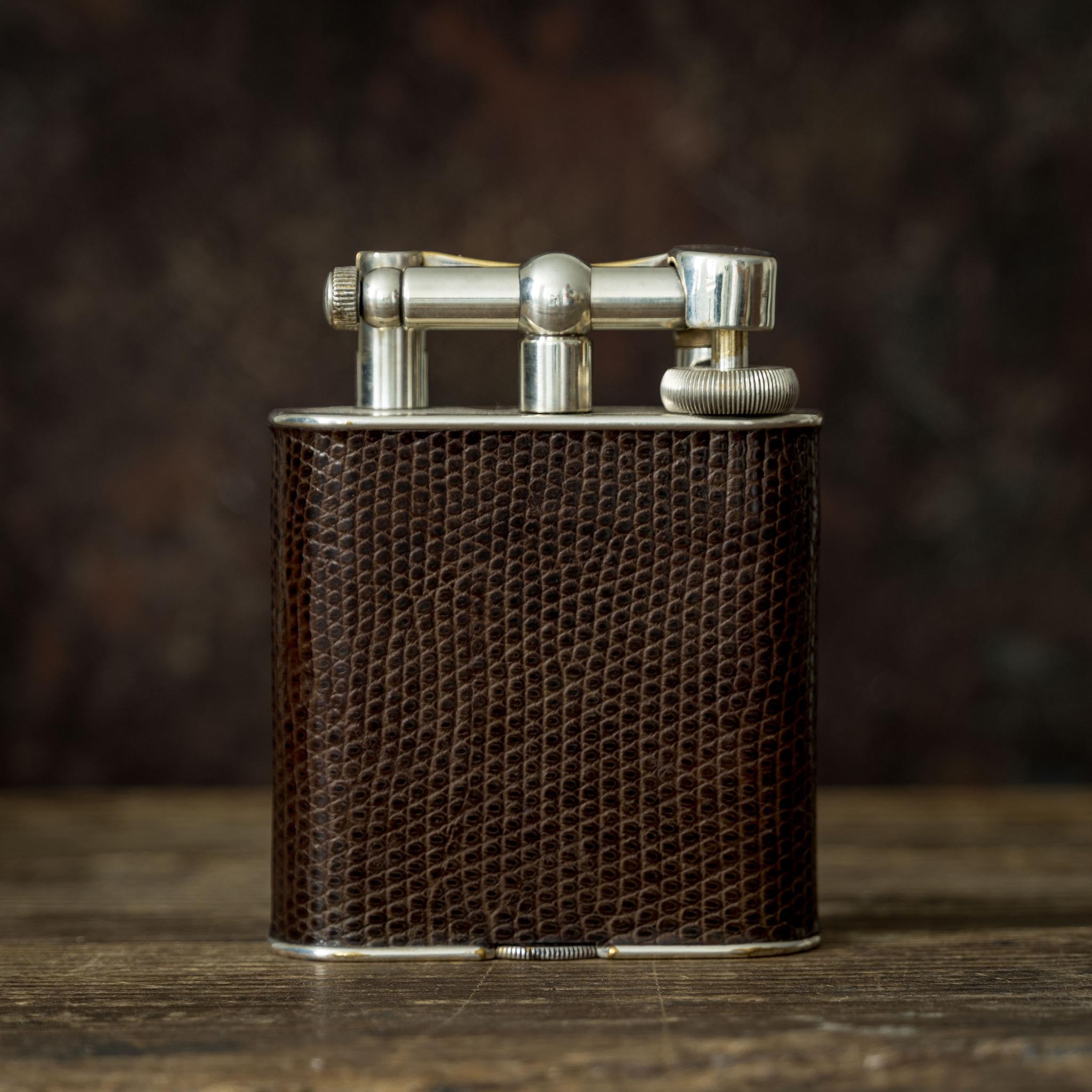 An unusual silver plated Dunhill 'Giant' table or desk lighter with Lizard skin covering to the body; circa 1950. The 'Giant' lighter was first seen in the Dunhill catalogue in 1929 and was an immediate success.

Dimensions: 10.5 cm/4? inches