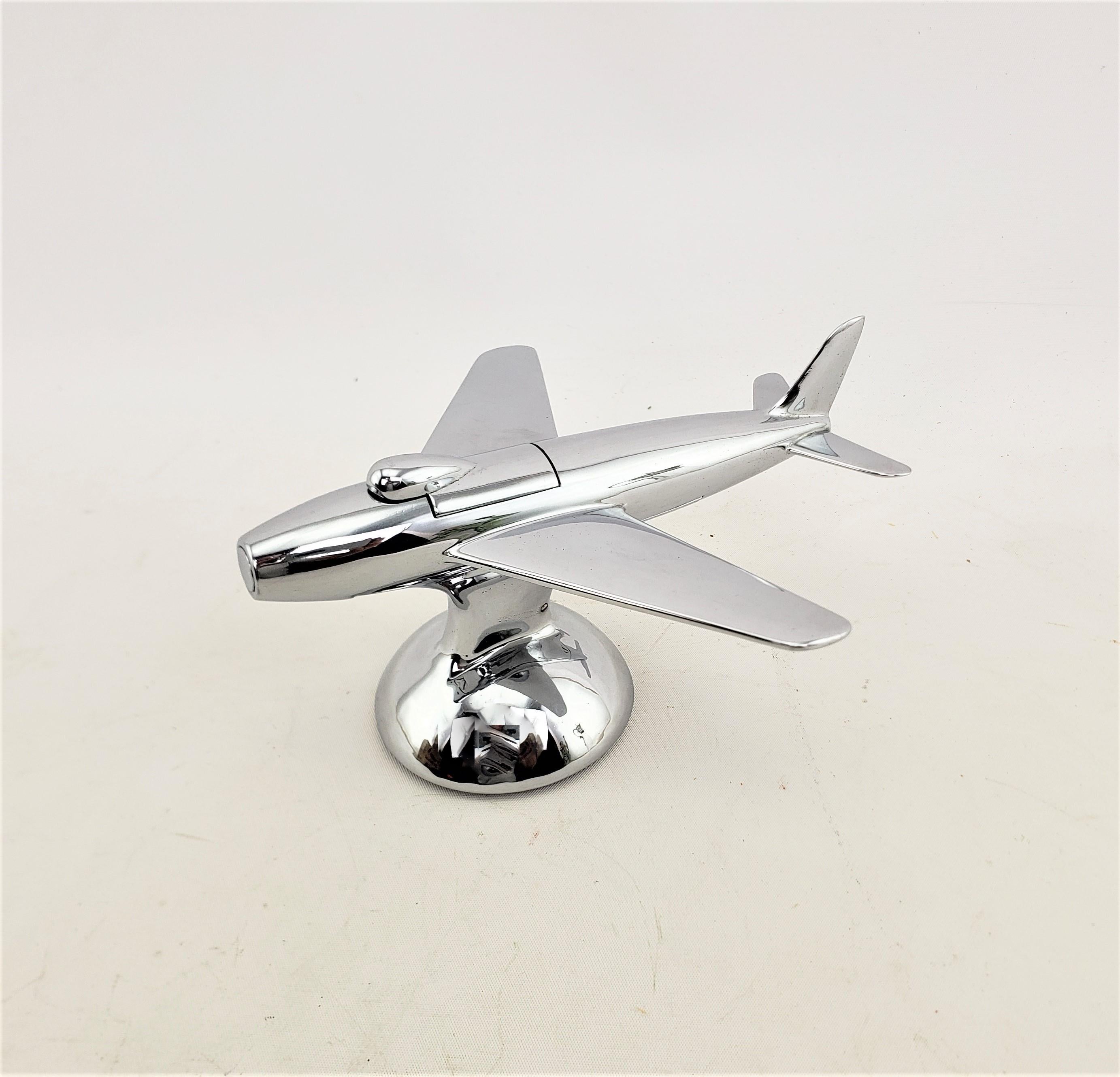 This chrome table lighter was made by the renowned Alfred Dunhill Company of England and dates to 1960 and done in the period Mid-Century Modern style. The lighter is made in the likeness of the F-86 fighter jet, which set world speed records some