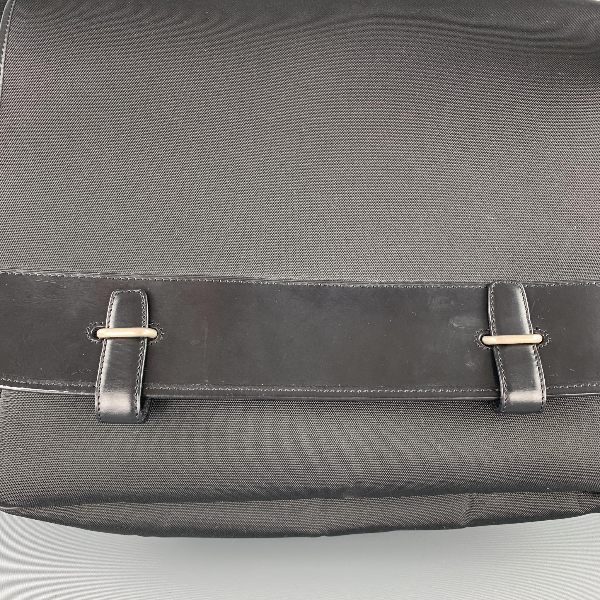 Vintage DUNHILL messenger bag comes in black nylon canvas with leather trim, side pockets, crossbody webbing strap with silver tone buckle, and top flap strap closures. 

Excellent Pre-Owned Condition.

Measurements:

Length: 13.5 in.
Width: 4.5