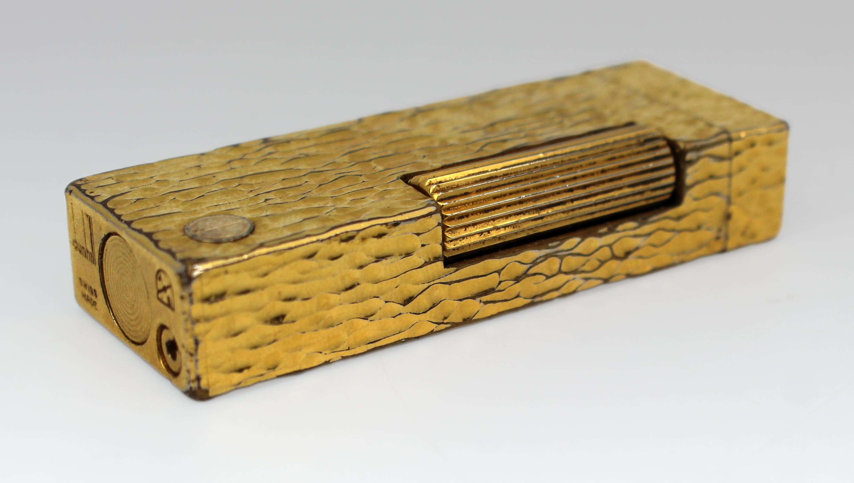 Dunhill Swiss-Made Gold-Plated “Bark” Finish Lighter, c.1965

A fine vintage Dunhill lighter, Swiss-made, dating to around 1965. Of rectangular form, the case is gold-plated and finished in the distinctive textured “bark” pattern associated with