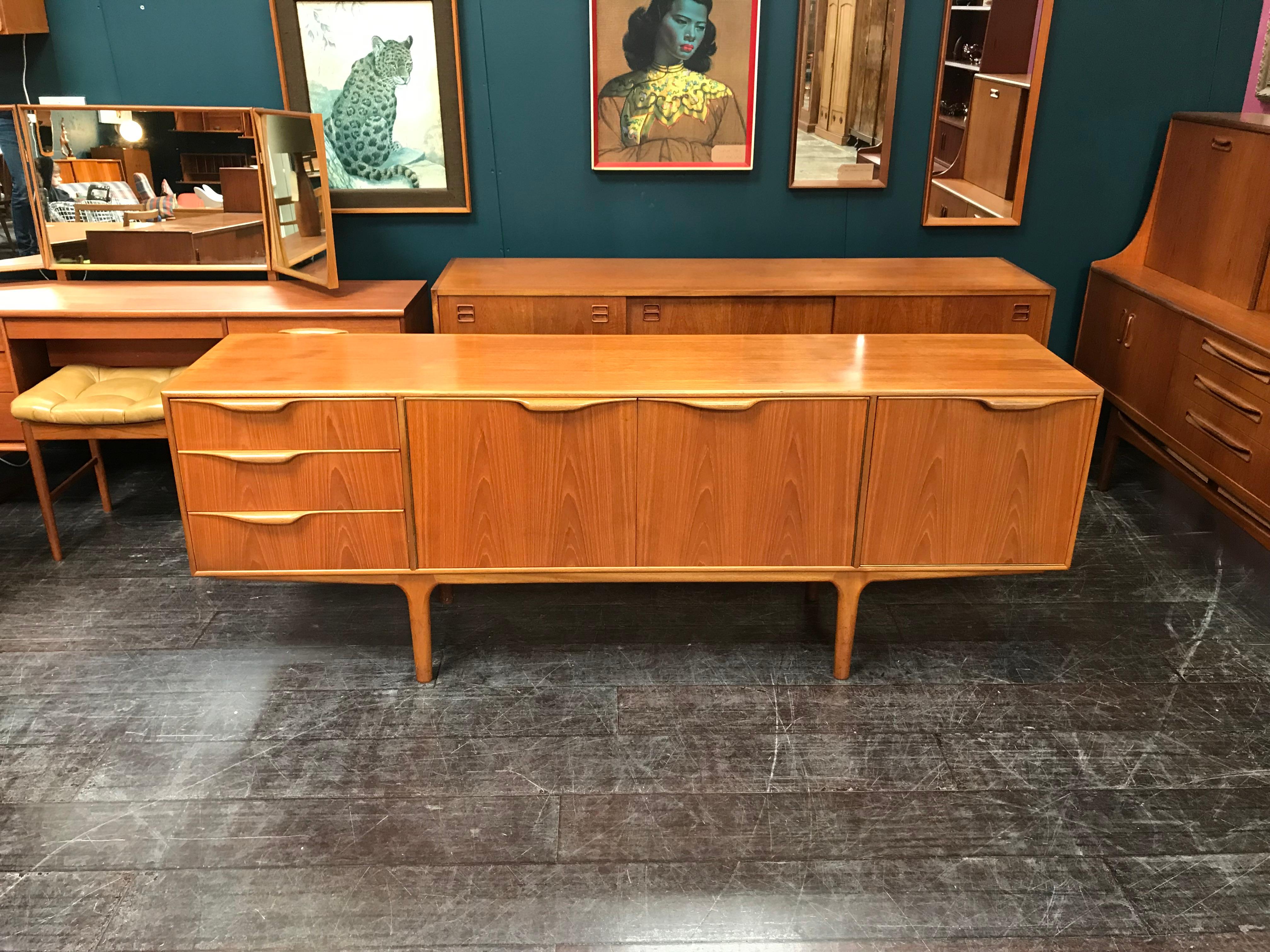 A vintage teak Dunvegan sideboard designed by Tom Robertson and manufactured by A.H. McIntosh of Kirkcaldy in the 1960s. This classic piece of mid century Scottish furniture features extensive storage with a double large shelved cupboard and drawers