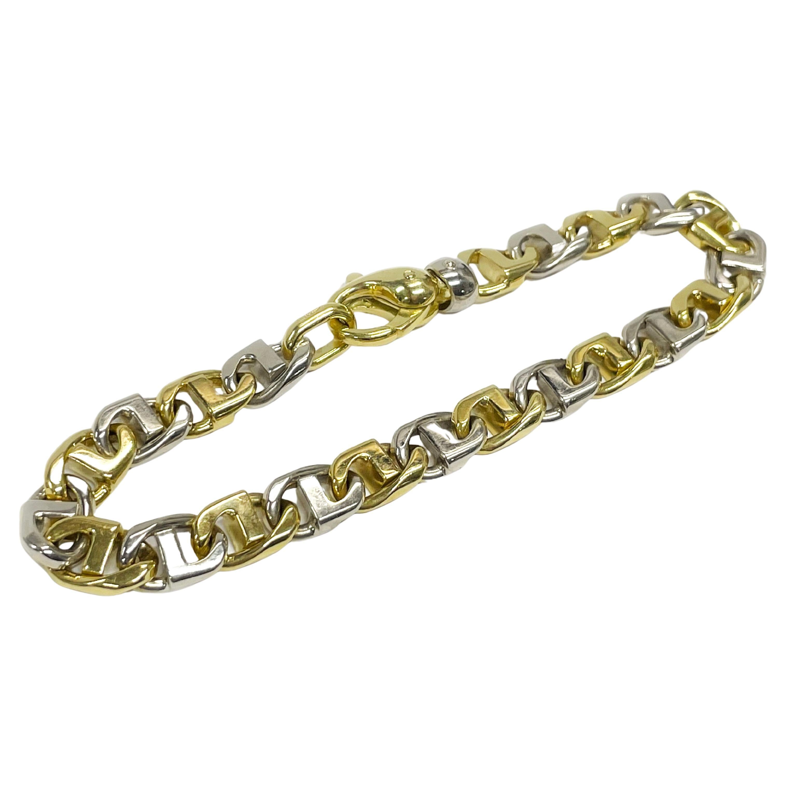 18 Karat Duo-Tone Fancy Link Bracelet. The bracelet features alternating white and yellow gold fancy links. Both the top and bottom of the bracelet links have a smooth shiny finish. The bracelet measures 8.5mm wide and is 8.75