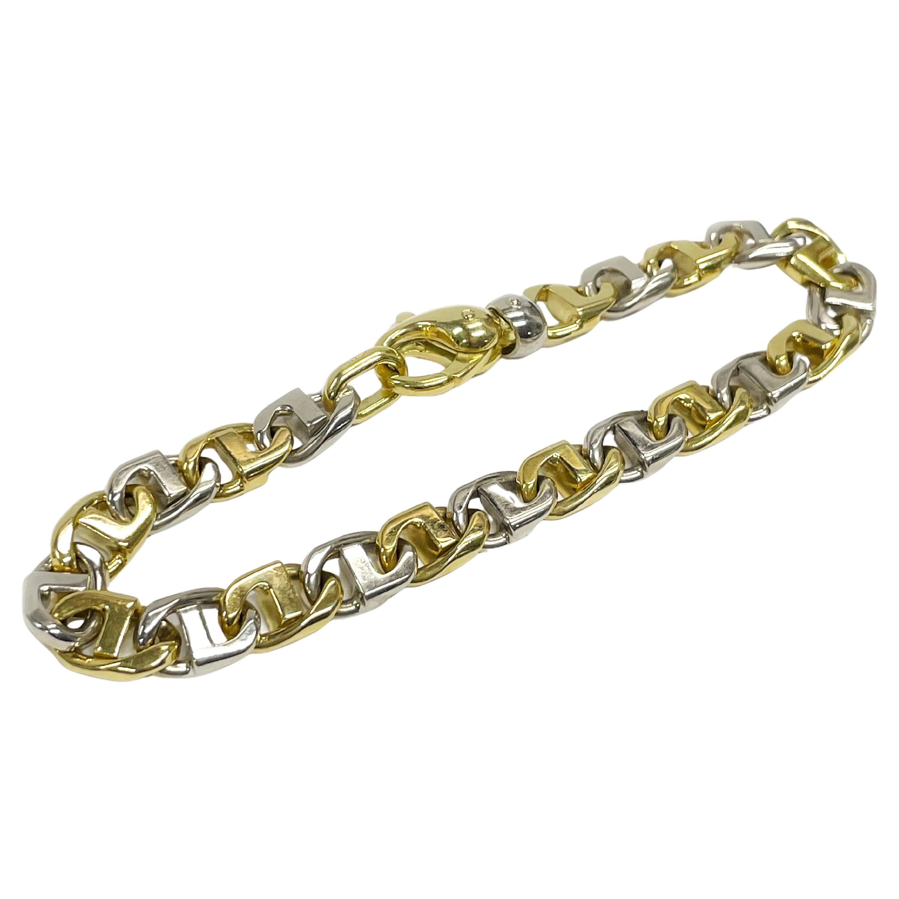 Bracelet à maillons fantaisie 18 carats. Le bracelet présente des maillons fantaisie en or blanc et jaune en alternance. Le haut et le bas des maillons du bracelet présentent une finition lisse et brillante. Le bracelet mesure 8,5 mm de large et