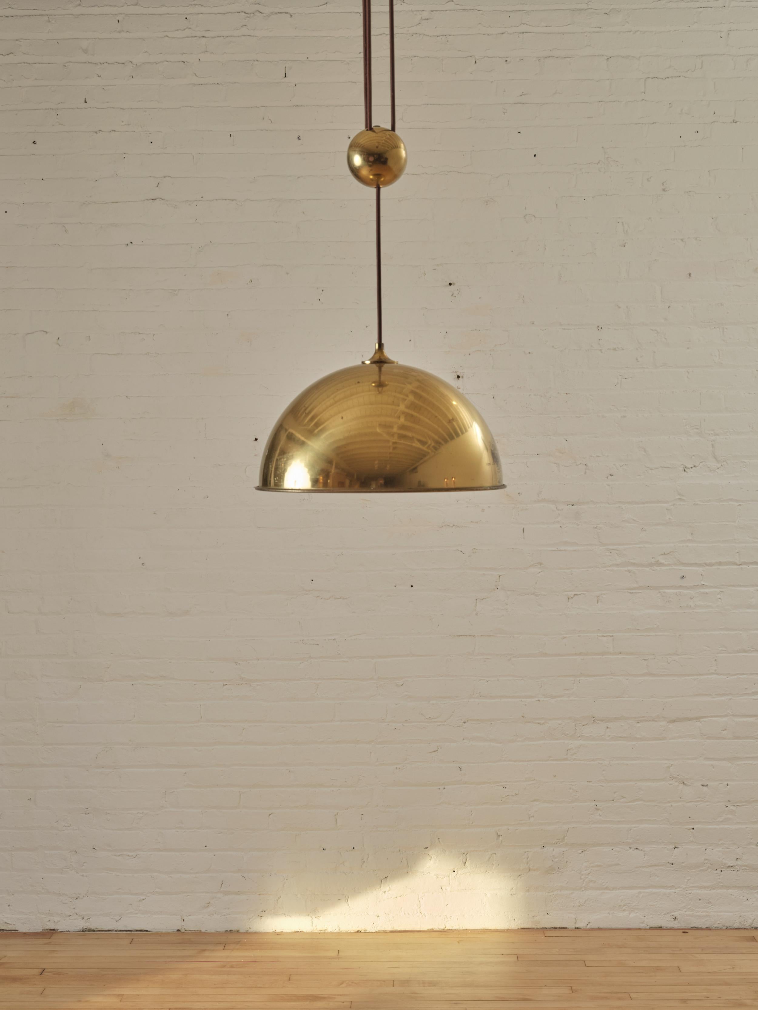 Duos 36' Counter Balance Pendant by Florian Schulz and Jens Schump in polished Brass featuring a center pull for height adjustment.

