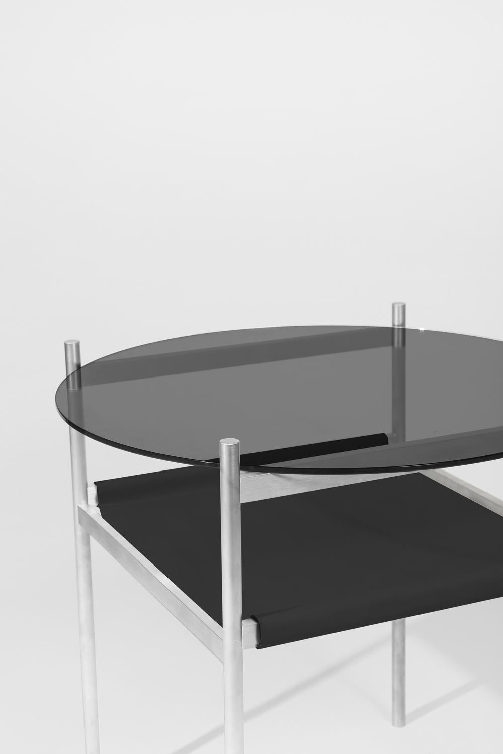 Made to order. Please allow 6 weeks for production.

Aluminium frame / Smoked glass / Black leather sling.

The Duotone Furniture series is based on a modular hardware system that pairs sturdy construction with visual lightness and a range of