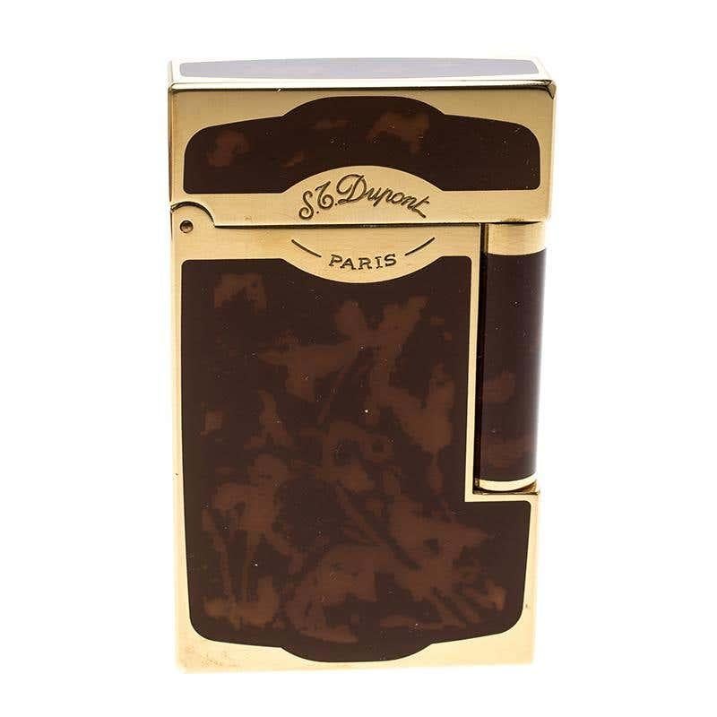 A classic combination of simplicity and techniques, this Ligne 2 S.T Dupont lighter tells a lot about your personality. It has been artfully crafted from a brown Chinese lacquer body and detailed with gold-plated metal on it. Carry it with you