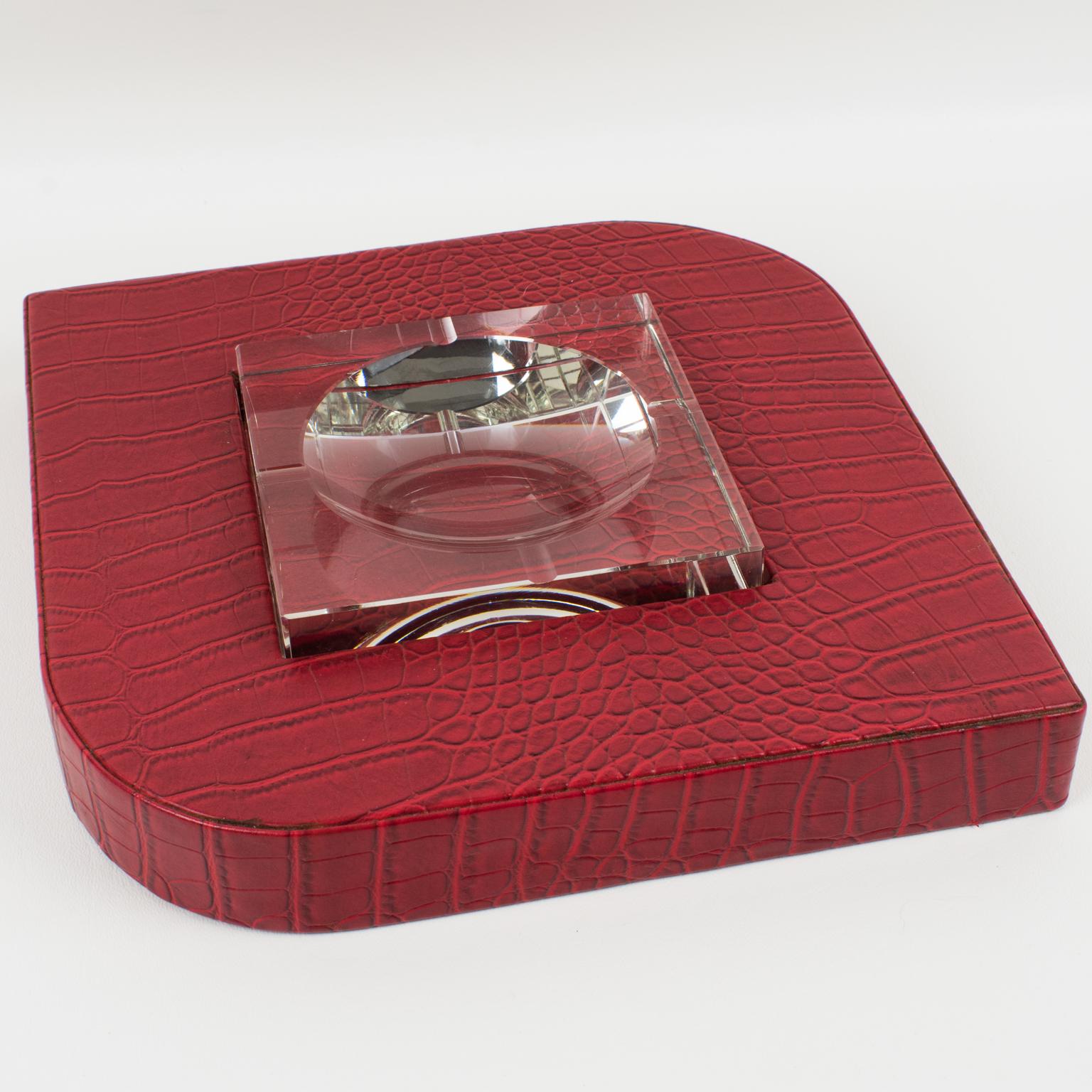 This stylish modernist red leather and crystal vide-poche has a design reminiscent of Dupre-Lafon's work and was crafted in the 1950s. The crocodile-embossed red leather adorns a geometric base, which holds a thick crystal ashtray with beveling.