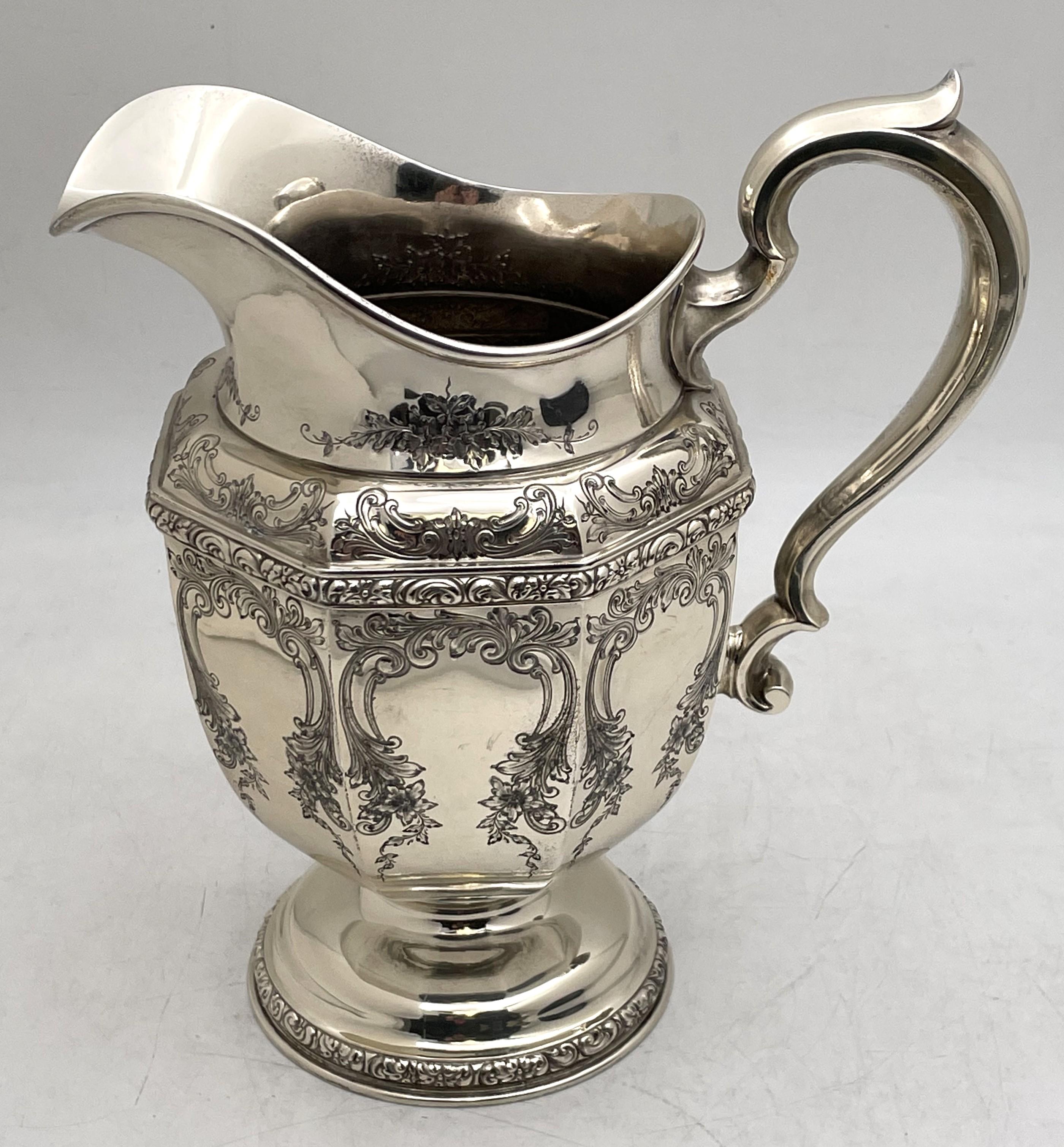 Durgin sterling silver pitcher or jug from the early 20th century, in Art Nouveau style, beautifully adorned with floral and curvilinear motifs. It measures 10 1/2'' in height by 9 1/2'' from handle to spout, weighs 33.4 troy ounces, and bears