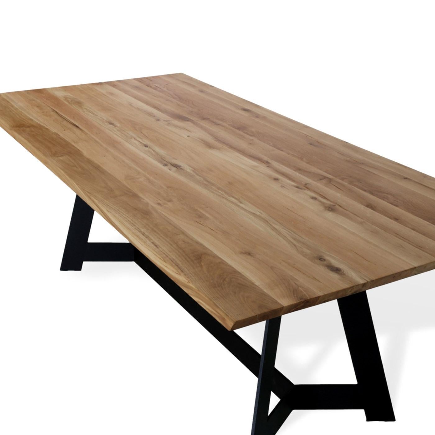 An exceptional definition of urban-minimalist style, this superb dining table will take center stage in a contemporary interior. Handcrafted of durmast wood with a clear natural finish, the top rests on a sturdy yet sleek black-lacquered metal base,