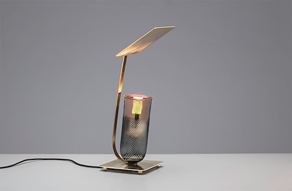 Handgefertigte Tischleuchte Dusk, entworfen von Brad Ascalon für GAIA&GINO. Die Dusk-Lampe besteht aus zwei Teilen: dem oberen Teil aus facettiertem Kristall, der von einem Sockel aus Messing gehalten wird, und der reflektierenden Spitze. 

Die