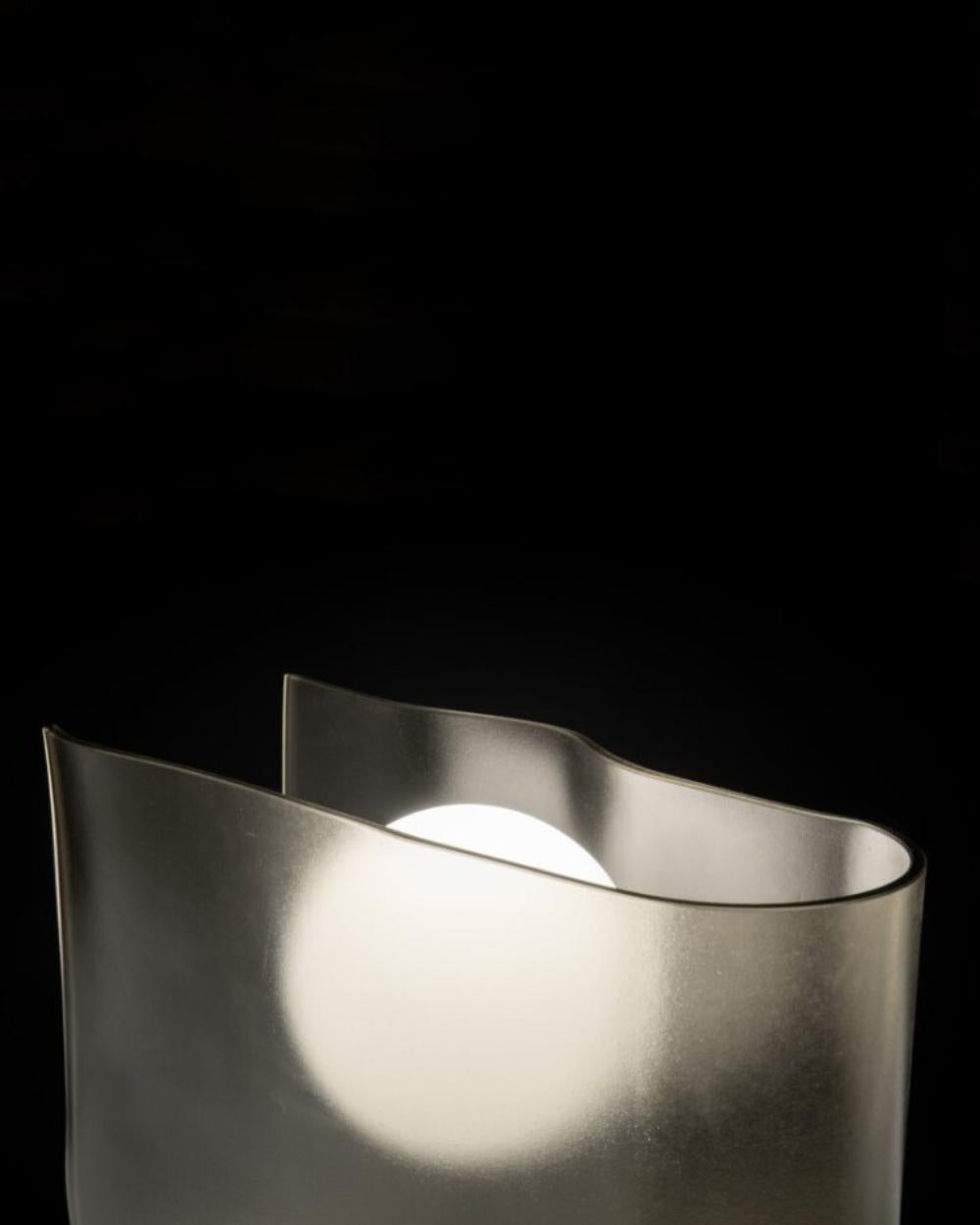 Capturant la douce lueur du crépuscule, la collection Dusk intègre une feuille de verre bronzé pliée avec une source lumineuse sphérique. Rendant hommage au symbolisme profond de la descente du soleil dans l'héritage culturel japonais, la