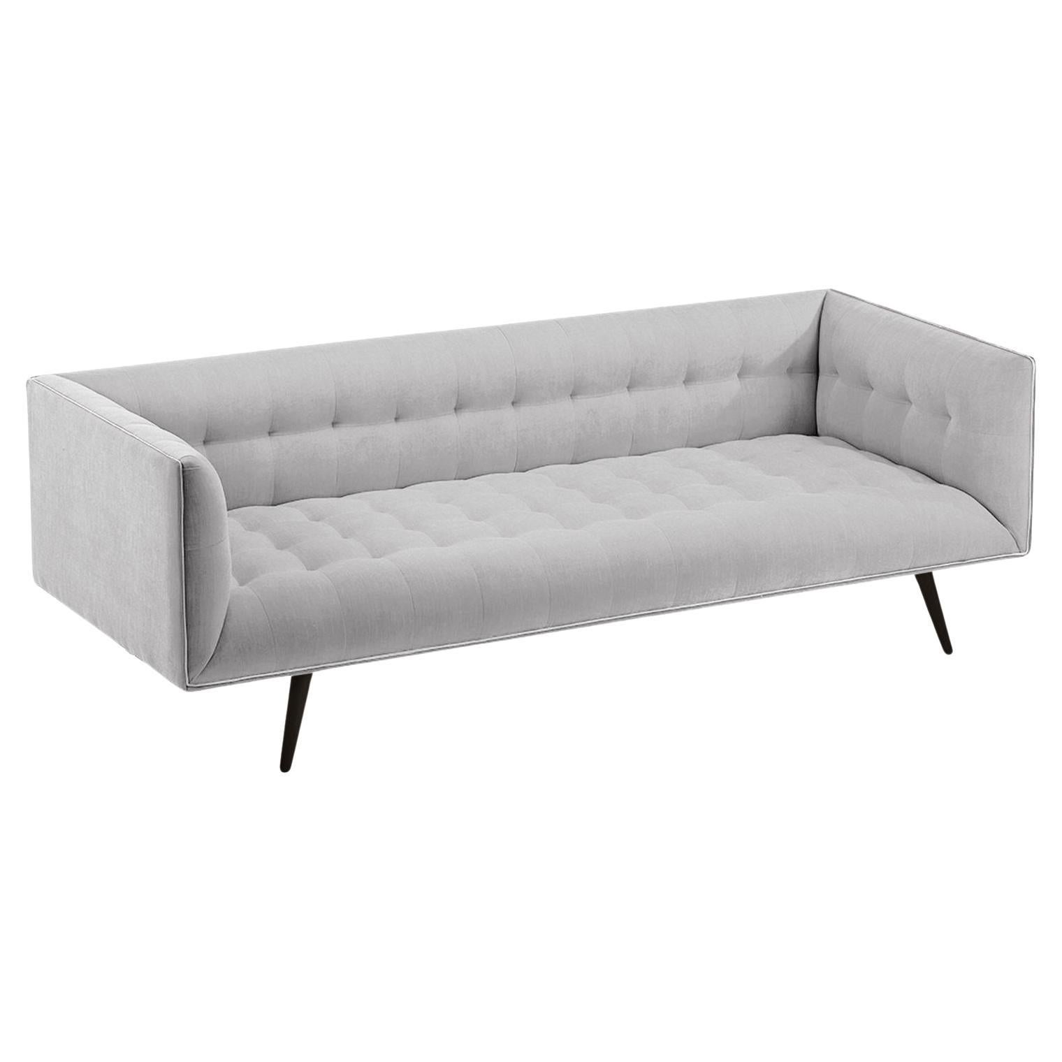 Das Dust-Sofa ist aus Massivholz gefertigt und verfügt über ein elegantes, getuftetes Aussehen und eine bequeme Sitzfläche. Handgefertigt mit einem Sockel aus Massivholz und Holzbeinen mit einem stilvollen Metallfuß aus poliertem Messing. Als Option
