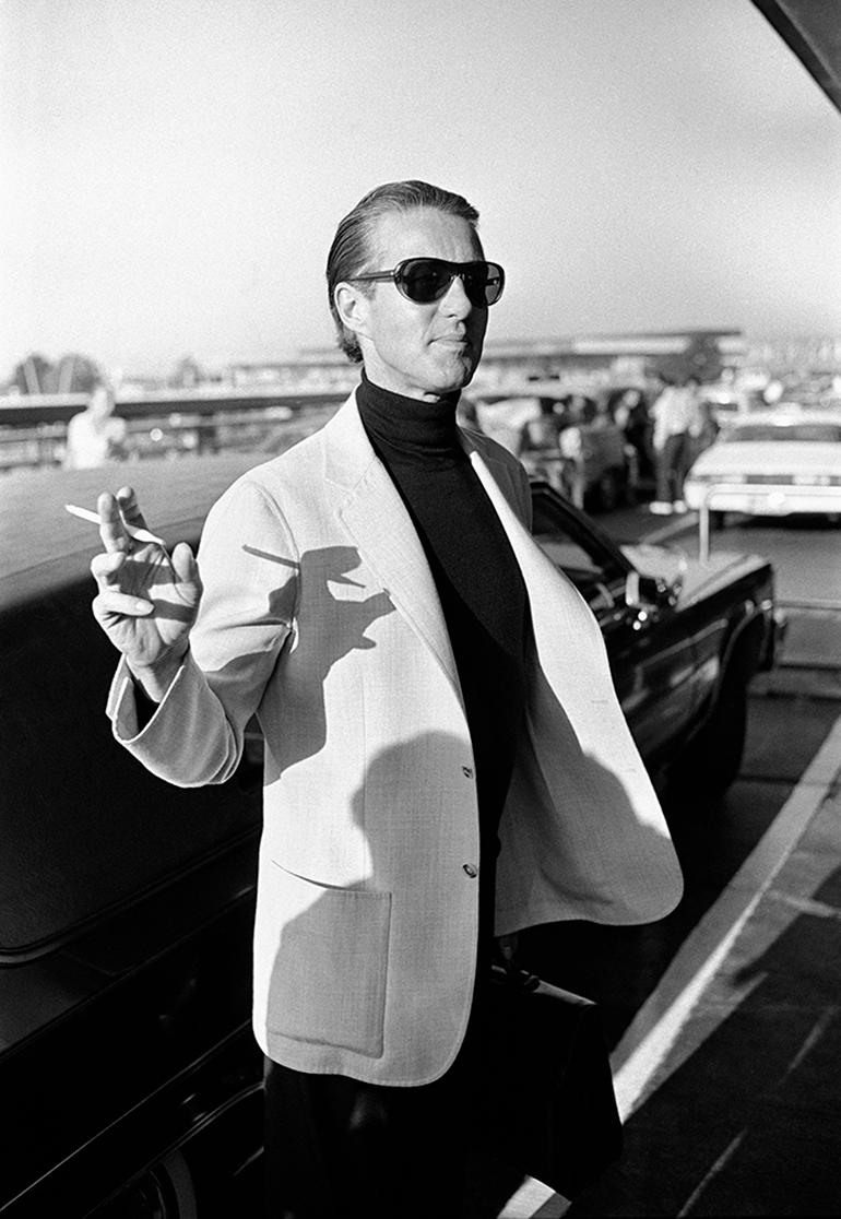Halston departing for China, JFK, 1980 - Gray Black and White Photograph by Dustin Pittman