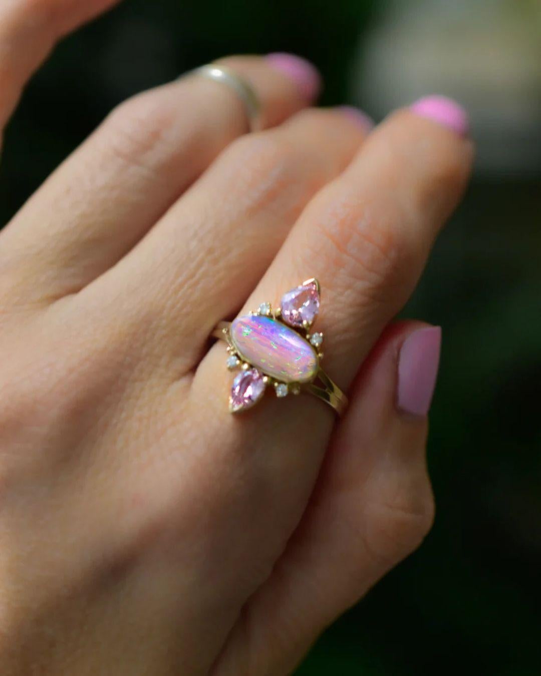Dusty Rose and Lavender Opal Trinity Ring with Soft Pink Sapphires and diamonds in Solid 14K Yellow Gold. 21mm in length.

This soft dusty rose opal has an ombre fade, mimicking a beautiful sunrise with purples and lime fire towards the top! Set in