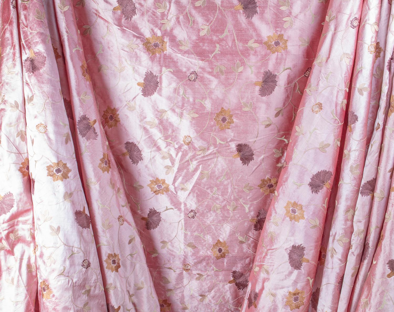 Beautiful dusty rose tone raw silk Dupioni fabric featuring intricate hand guided chain stitch embroidery of saffron, garnet, amethyst floral and celedon trellis motif. 100% hand dyed raw woven silk.