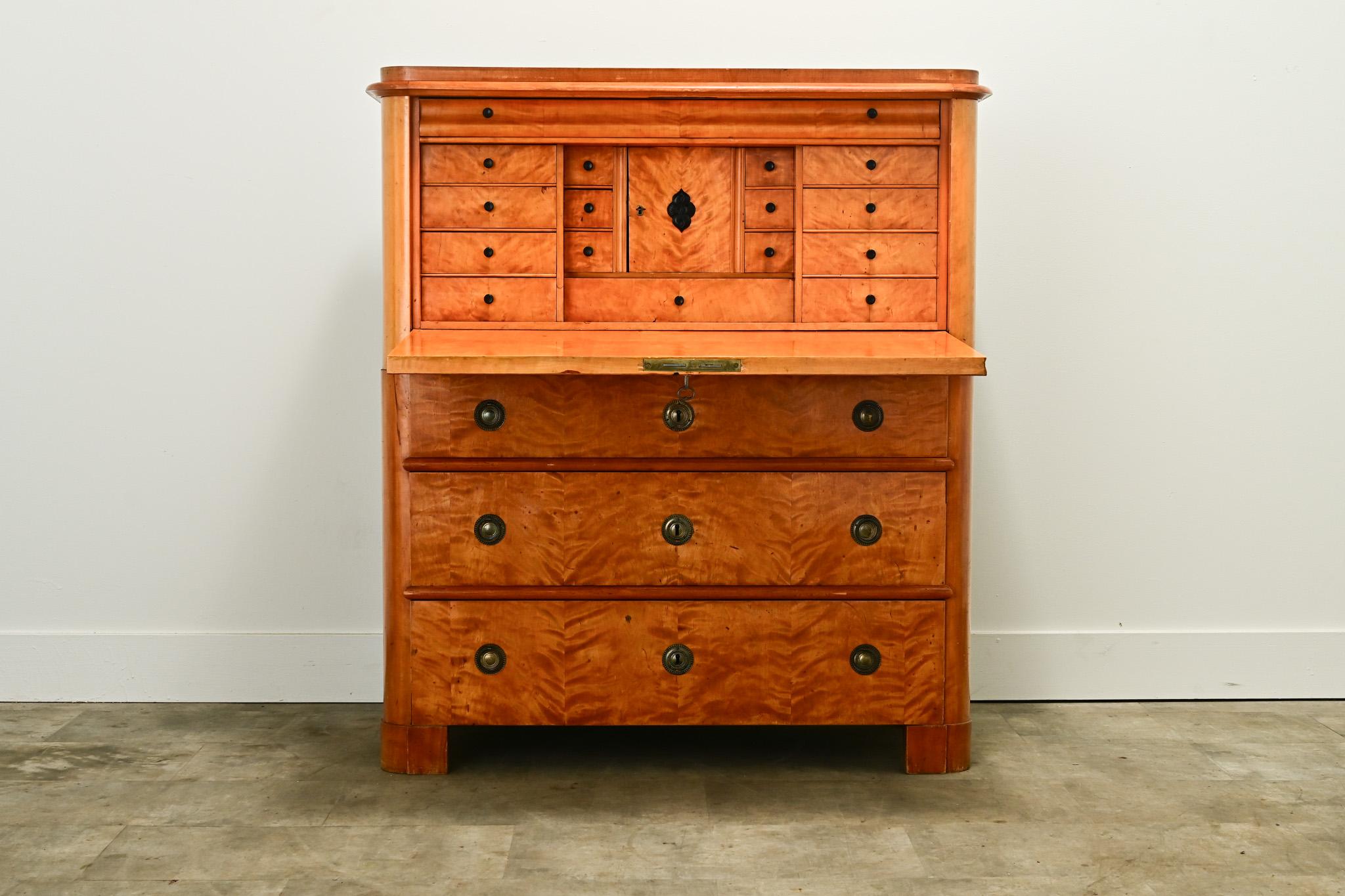 An impressive 19th century birch secretary made in the Netherlands circa 1800. The exterior is simple in design, celebrating the beautifully figured burl and bookmatched birch wood. At the top the cabinet has a carved bone escutcheon plate opening