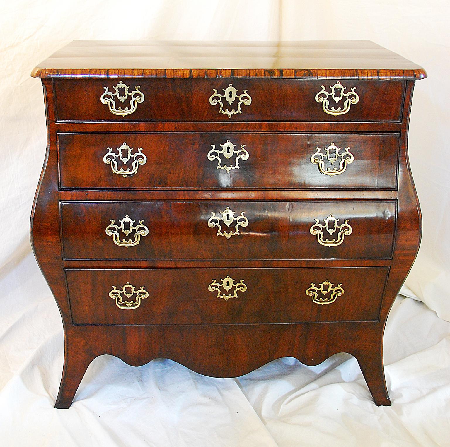 This small Dutch Bombay chest of drawers of exquisite proportions, made in the late 18th century, was crafted using mahogany and crossbanded with coromandel. The drawers are oak lined. The deep shaped skirt and flared out feet accentuate the curves